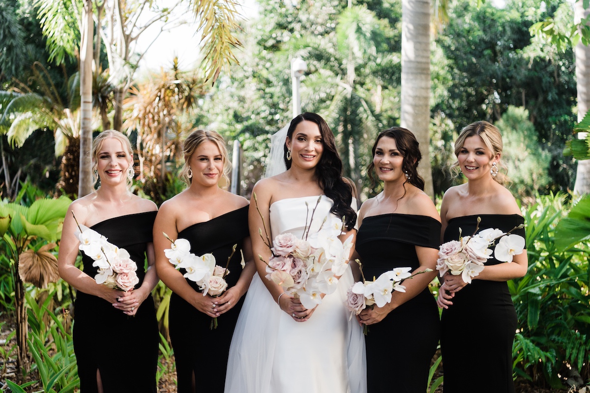 bride and bridesmaids bouquets of white phalenopsis orchids, magnolia branch and roses