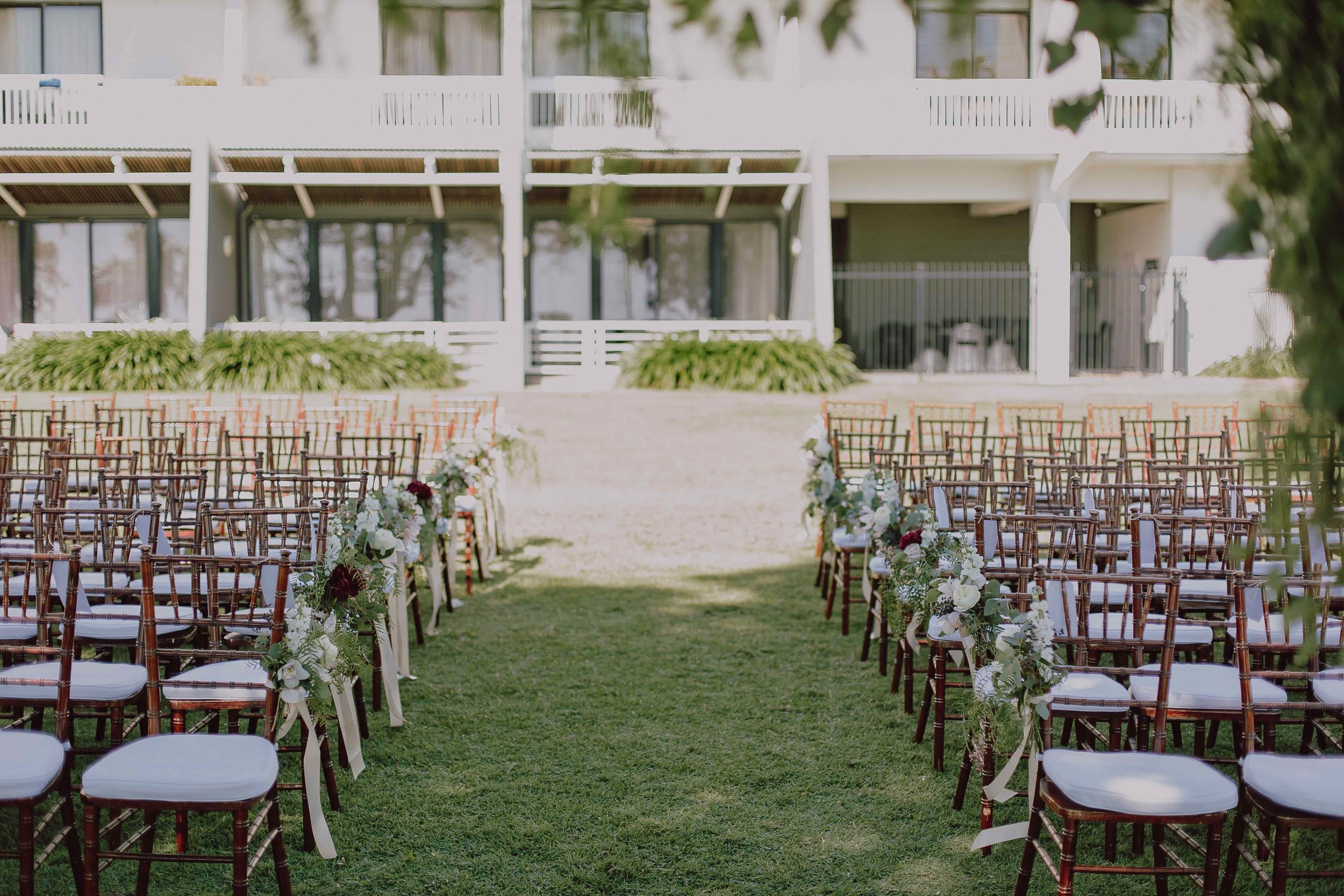 Rows of walnut Tiffany chairs on the lawns at Mindel Beach Casino and Resort for a Darwin wedding.