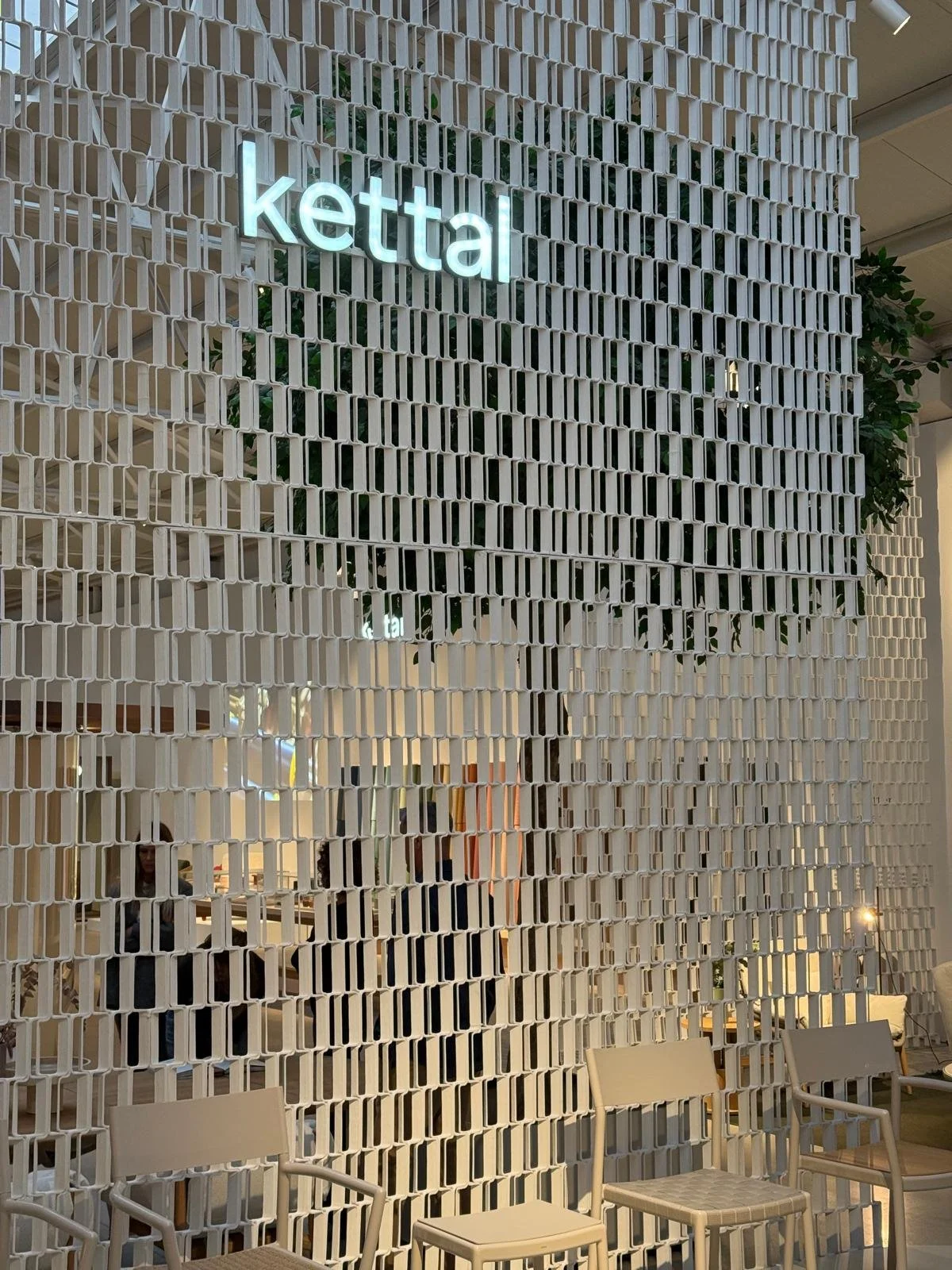   Kettal detail:  Lateral view of the white Nazka Screen featuring the Kettal logo, displayed at Salone del Mobile 2022. 