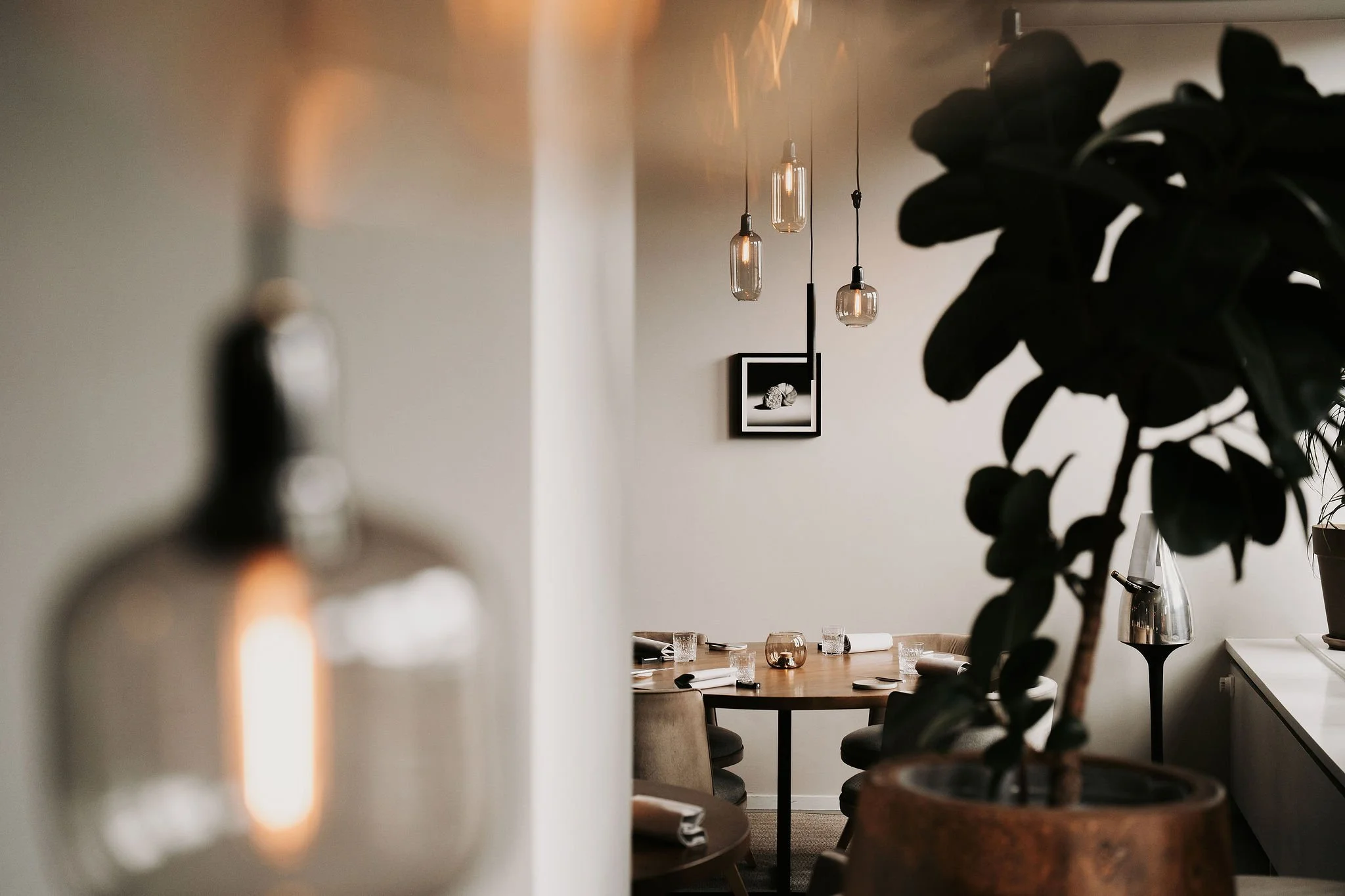 Table composition: Atmosphere detail of a restaurant table accented with greenery, reflecting the harmonious design by Studio Michiel Wijnen