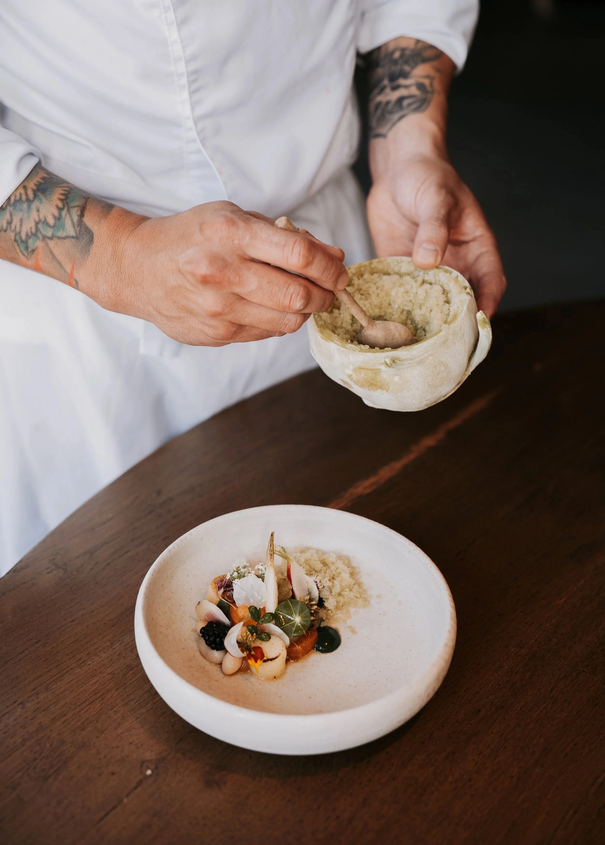 Chef at work: Executive chef meticulously preparing a gourmet dish in the professional kitchen of Restaurant Vermeer.