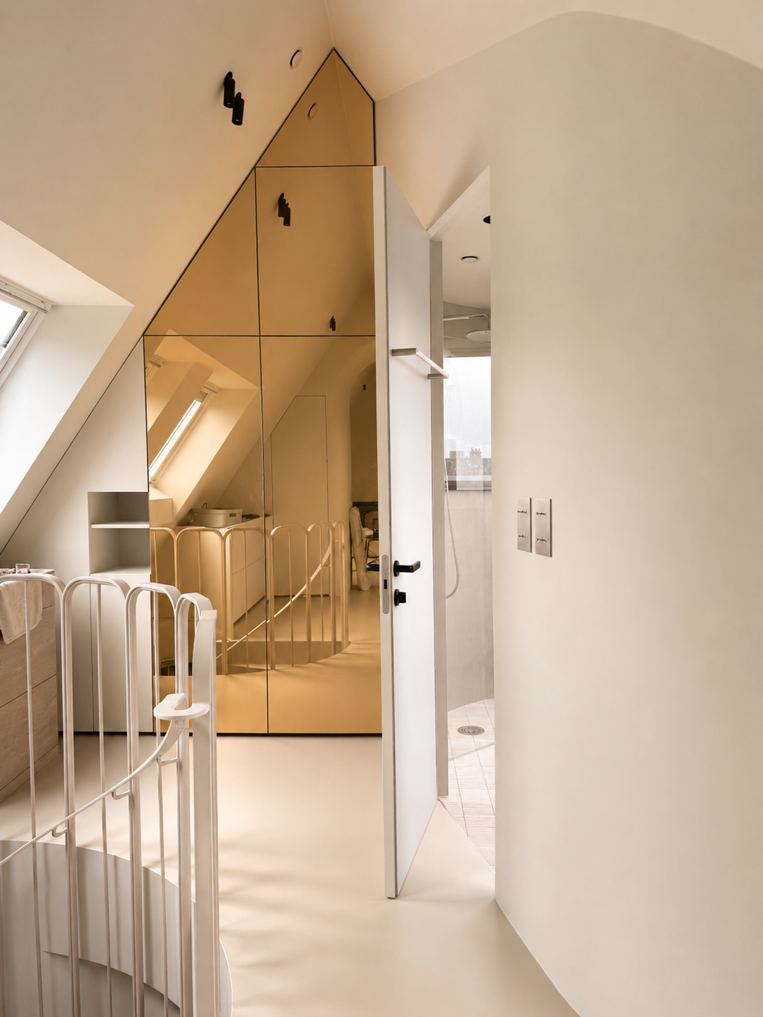 19. Attic master suite: Top-floor mansard bedroom featuring a soaring pitched ceiling, a warm gold-framed mirror, a built-in wardrobe niche, and an open doorway leading to the bathroom.