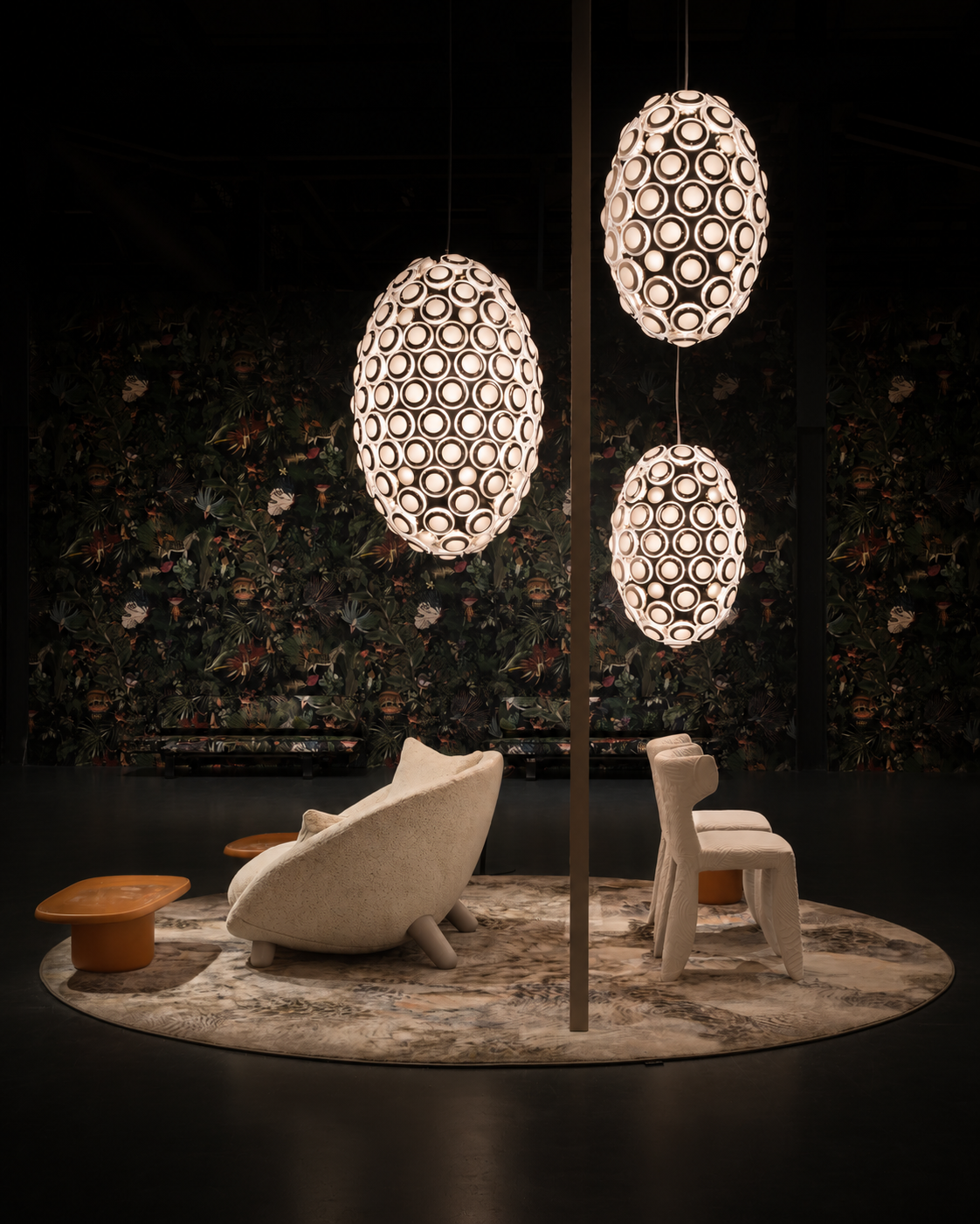 Seating area detail: Lateral view of Moooi seating arrangements designed by Studio Michiel Wijnen, illuminated by spherical pendant lamps over a circular floral rug.