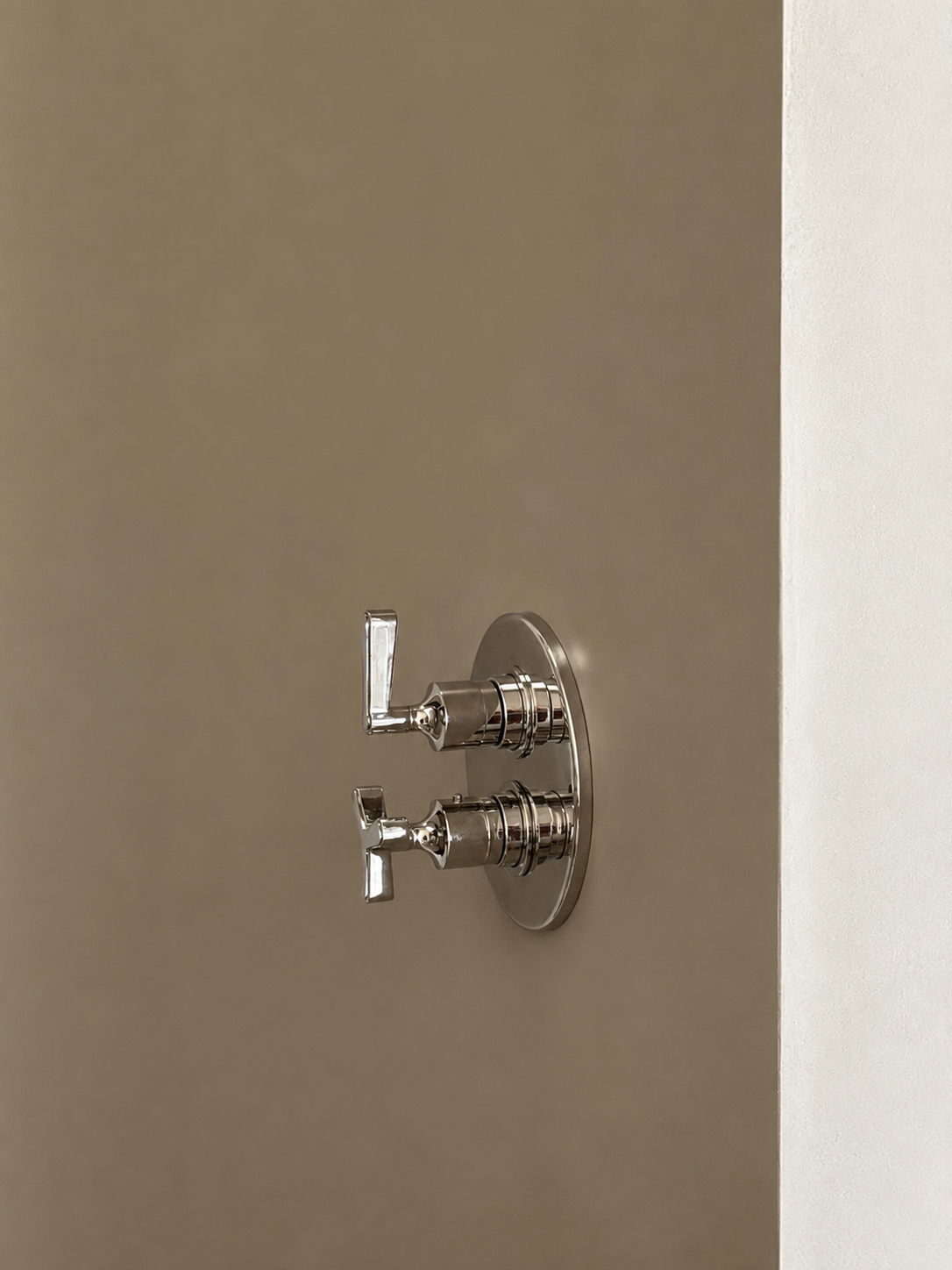 13. Shower fixture detail: Close-up of the sleek wall-mounted shower mixer and controls by the Watermark collection.