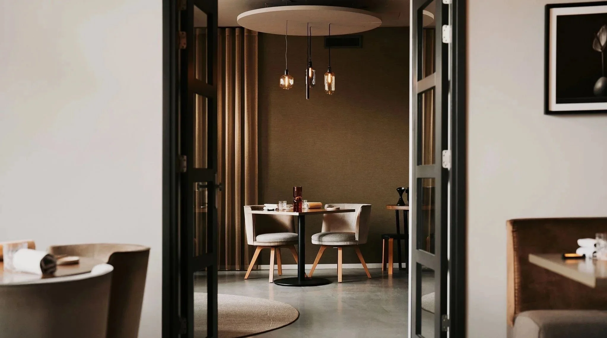 Spatial transition: View through the elegant restaurant space showcasing a quiet seating nook by Studio Michiel Wijnen.