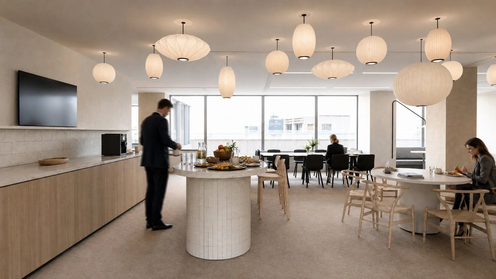 . Dining hub: Lunch area at WGL Rotterdam featuring a central island with white tiles and soft-form Japanese-style paper pendant lamps, designed by Studio Michiel Wijnen and Studio Tyner.