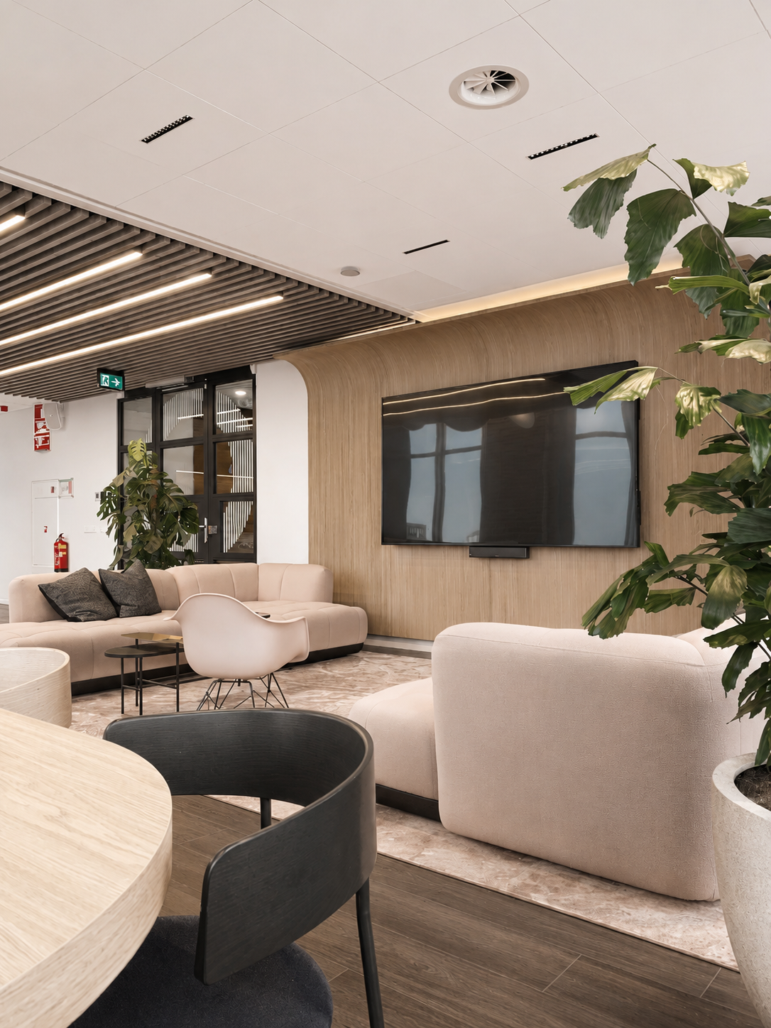 Social hub: Soft seating area featuring a curved oak wood wall, integrated media, and indoor greenery, designed by Studio Michiel Wijnen and Studio Tyne