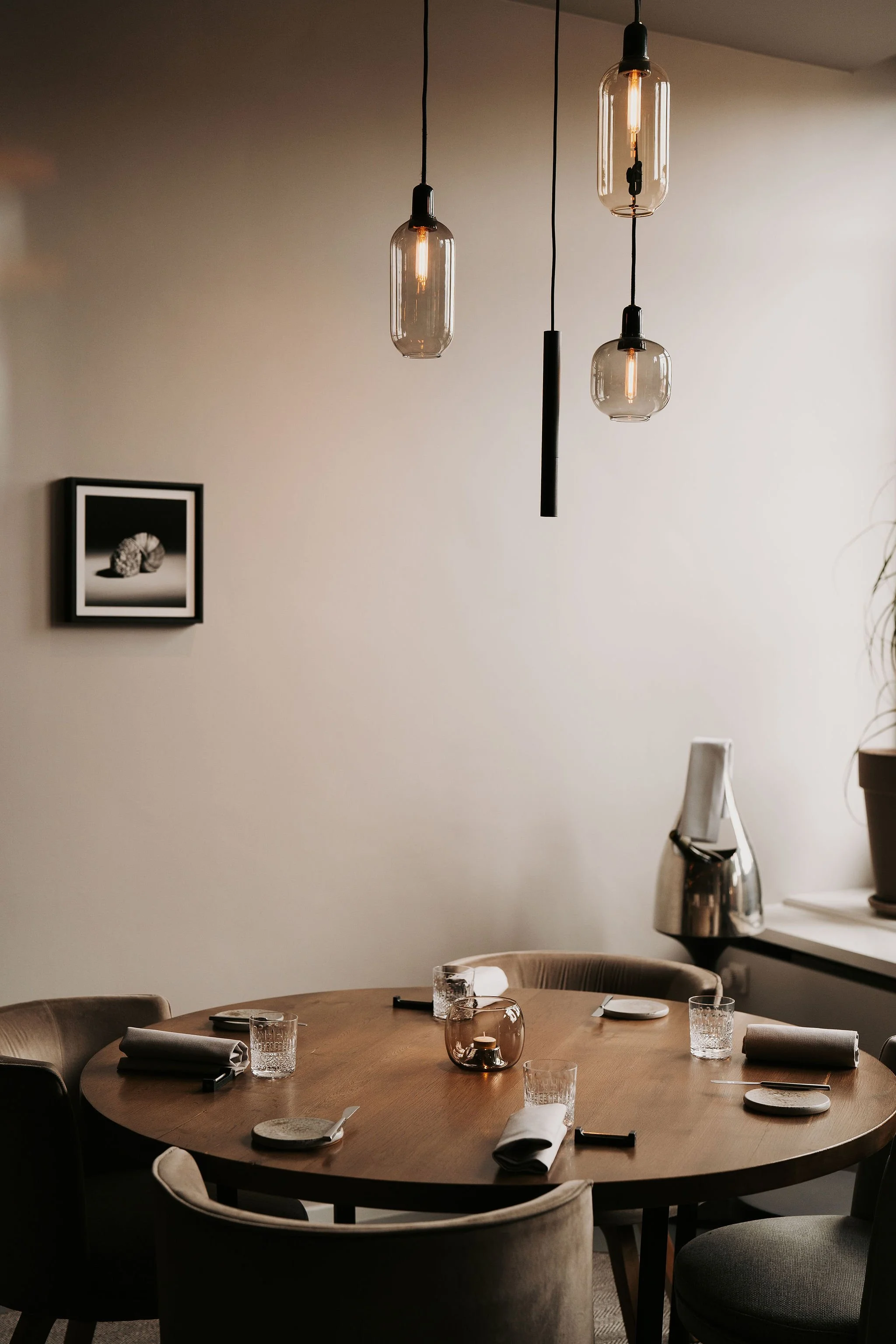 Dining setup: Intimate table setting with pendant lighting in the cozy dining area of Restaurant Vermeer, Amsterdam.