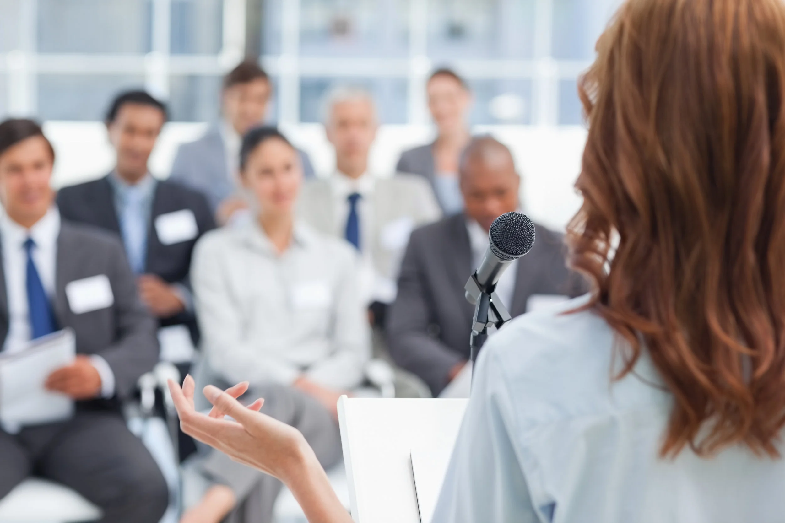 Woman-gesturing-while-making-a-speech-to-business-team-450306057_3867x2578.jpeg