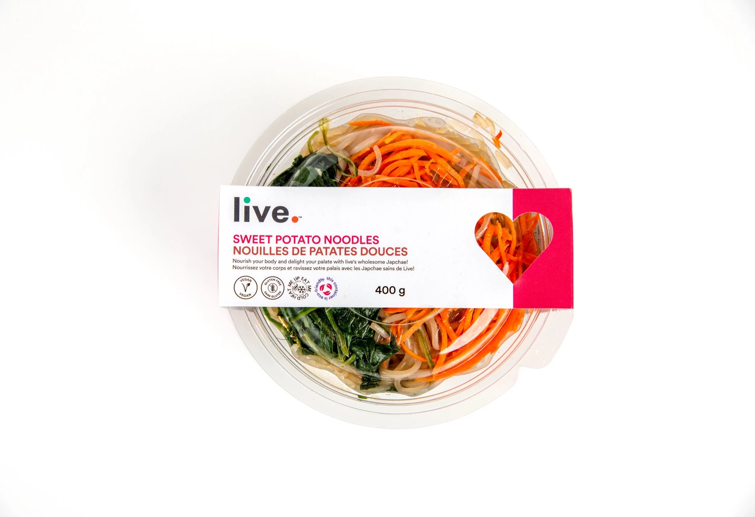 Clear plastic container of sweet potato noodles with carrots and greens, labeled 'live. Sweet Potato Noodles' on a white background.