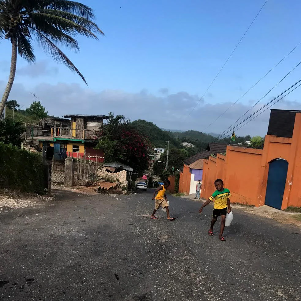 In Nine Mile, a remote mountain village of Jamaica, young children and the elderly are tasked with carrying water from the run-off water source to their homes.