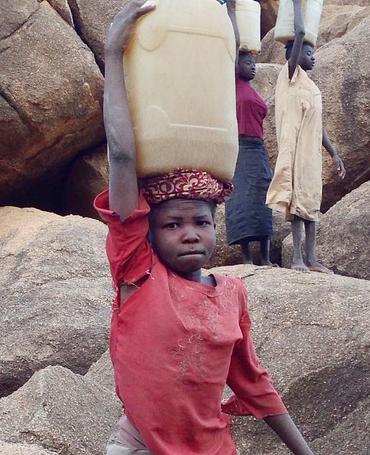 11-year-old Rhemas carrying water to her family