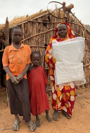 A family receives a shelter tarp