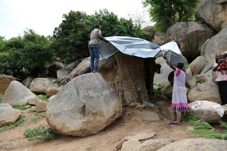 Tarps protect families from the elements.