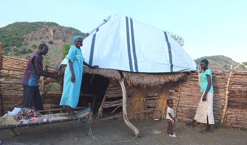Tarps protect families from the weather.