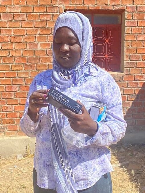 This woman learns how to use a Bible radio.