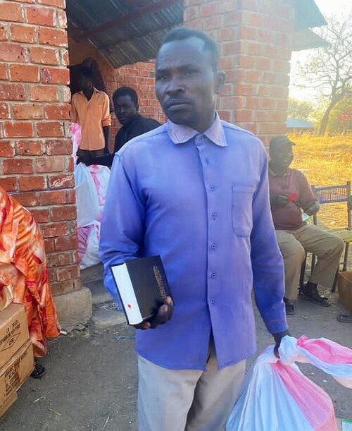 This man receives a Bible with his emergency relief pack.
