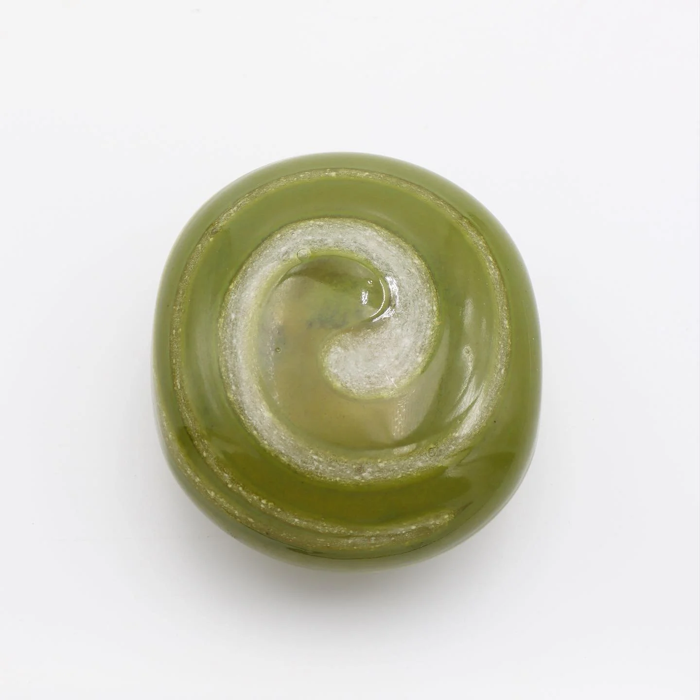 Glass skipping stone with cremation ashes, in moss.