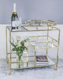 Drinkvagn som andas Art Déco. Elegant blankpolerad ram i silverfärg och spegelglas med facettslipade kanter. På den här drinkvagnen får du plats med alla dina finaste glas, flaskor och andra personliga accessoarer. Pris 8995 kr. Beställningsvara. Mått: L80/B46/H80,5 cm