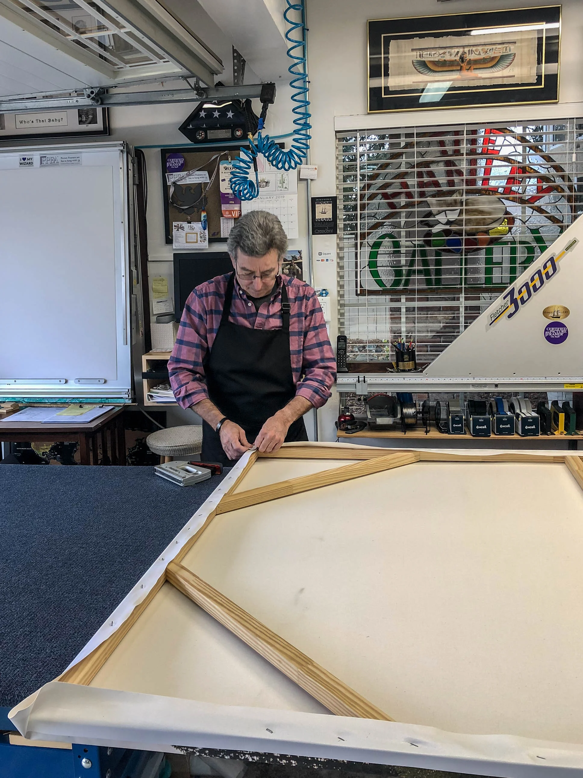 The canvas being attached to the frame.