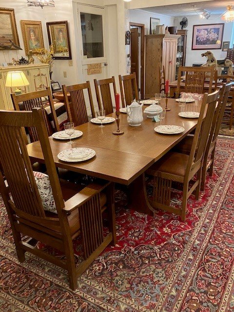  EL-1 Stickley Dining Set. Table with 2 end leafs and 8 chairs (2 arm chairs). Solid quarter sawn oak. Trestle style base. Faux Ostrich Vinyl on seats. Circa late 1900’s. Table is 76” L without end leafs, 106” L with both end leafs. 42” W. 30” H. Sea