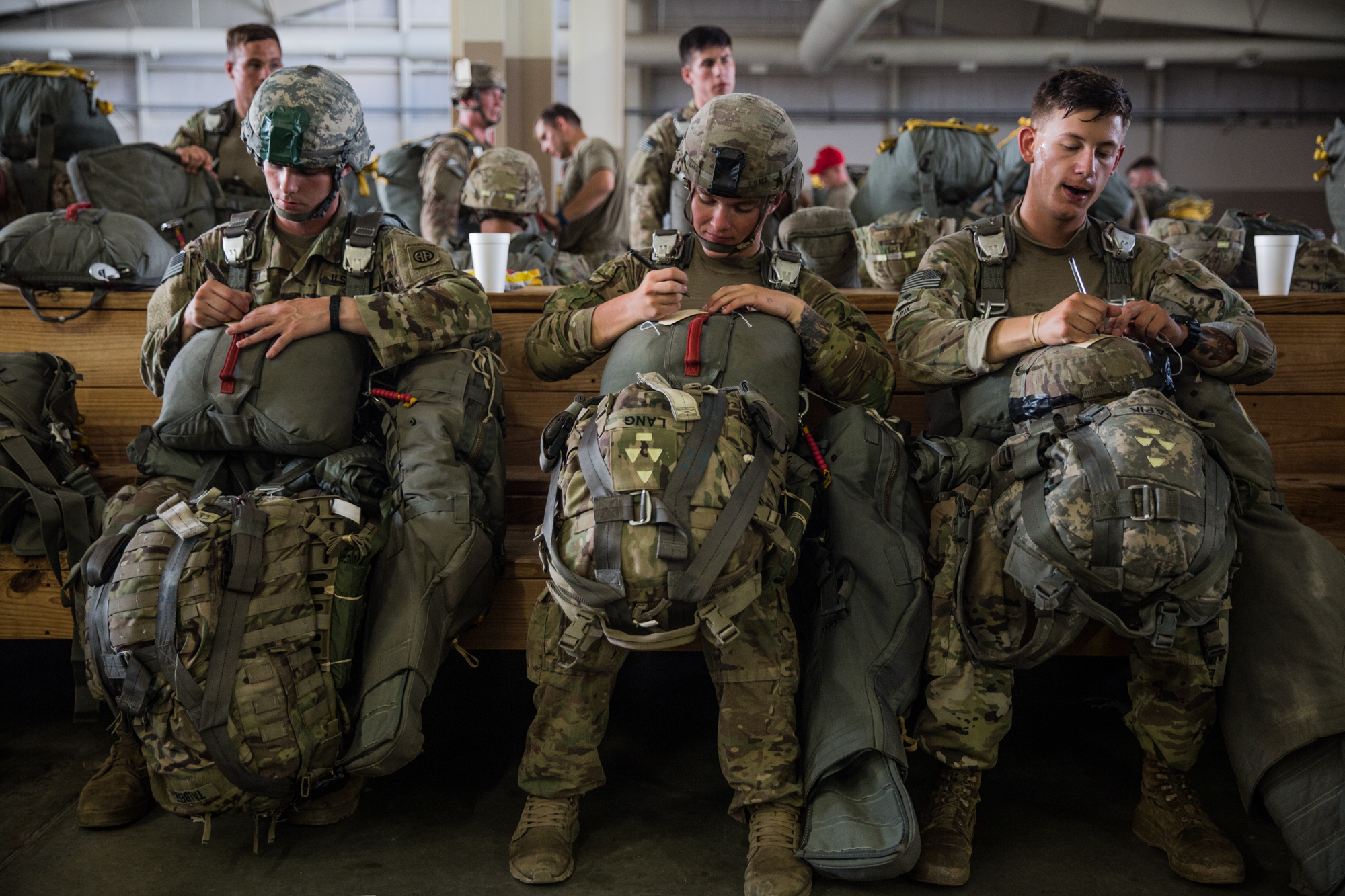 Paratroopers Talbert, Lang and Capik of the 82nd Airborne Division write their name, rank, and unit on name cards before an upcoming training jump at Fort Bragg, N.C. on July 26, 2017. 