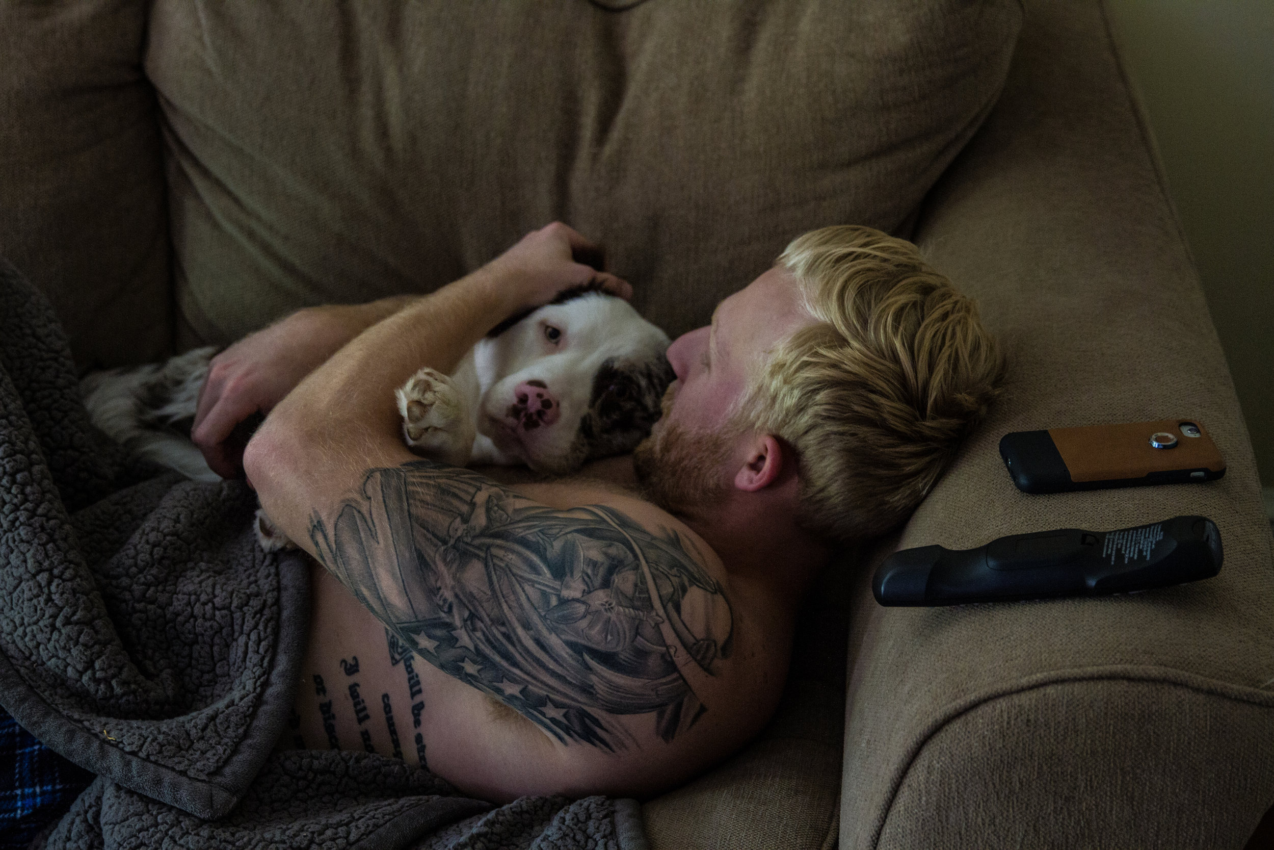 Fontenot holds his dog, Caliber, as he watches ESPN in the morning. “I tell people I’m just a single dad trying to make it with my son,” laughs Fontenot. “Little do they know my son is my dog.” On his shoulder, Fontenot had his interpretation of a G