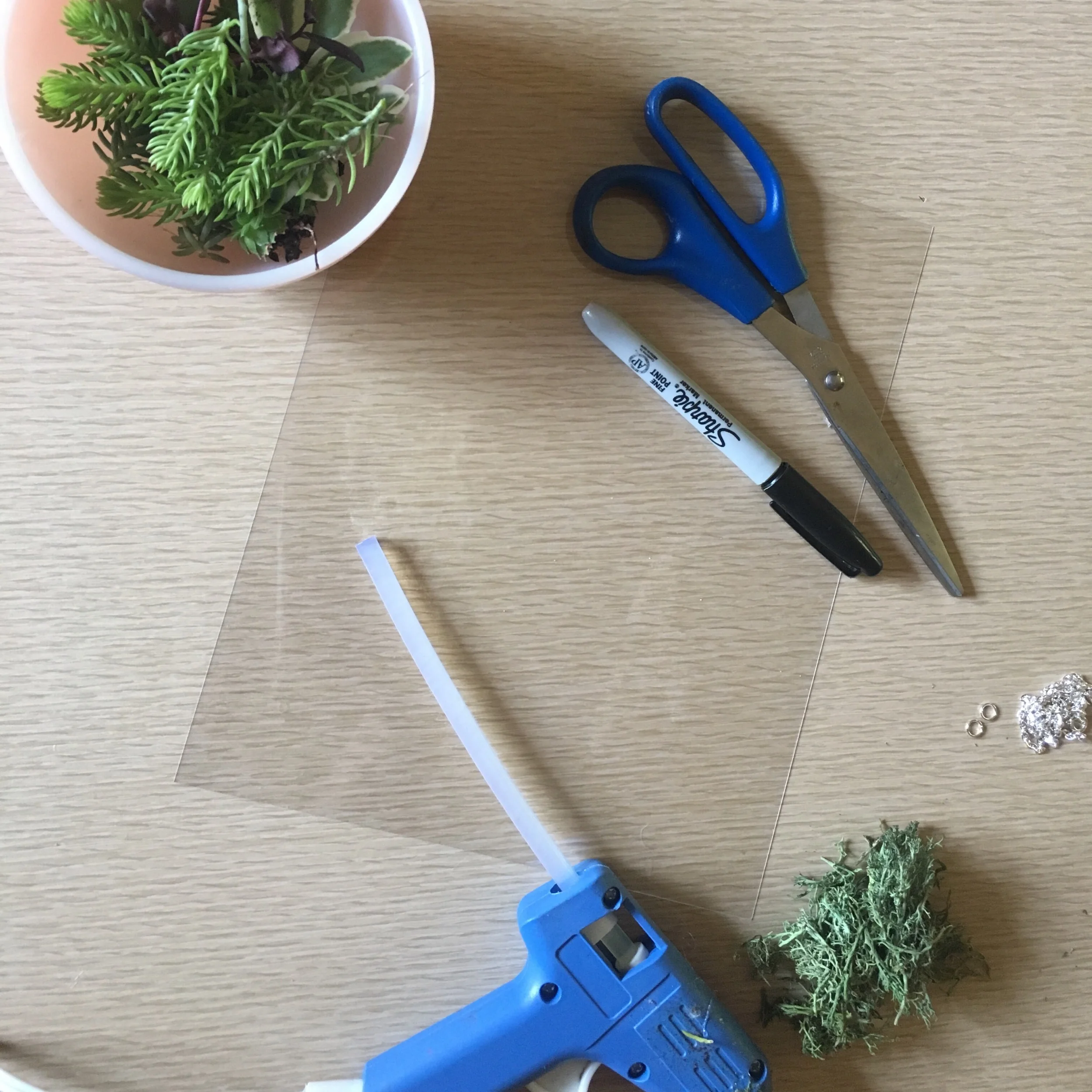 Step two: gather or purchase this stuff- some reindeer moss (or other preserved moss), a chain and closure, jump rings, a piece of shrink film, scissors, a sharpie and a hot glue gun (with glue). You will also need a hole punch, needle nose pliers, oven and baking tray of some kind. Preferably vintage Jadeite but IDK. I also really like to add little crystals or fancy stones, but not today.