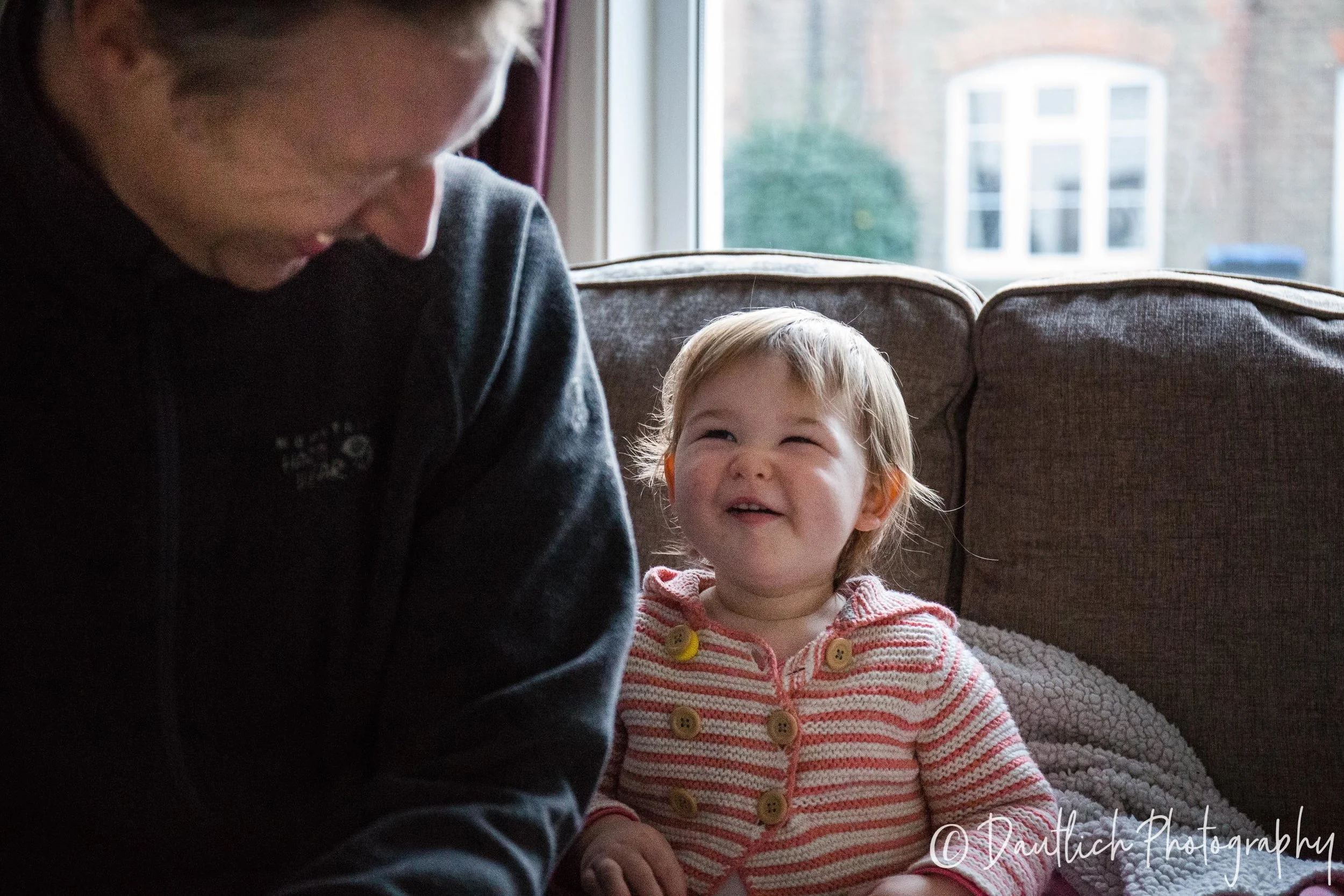 Nick and Hazel laugh together on the sofa in Haywards Heath.