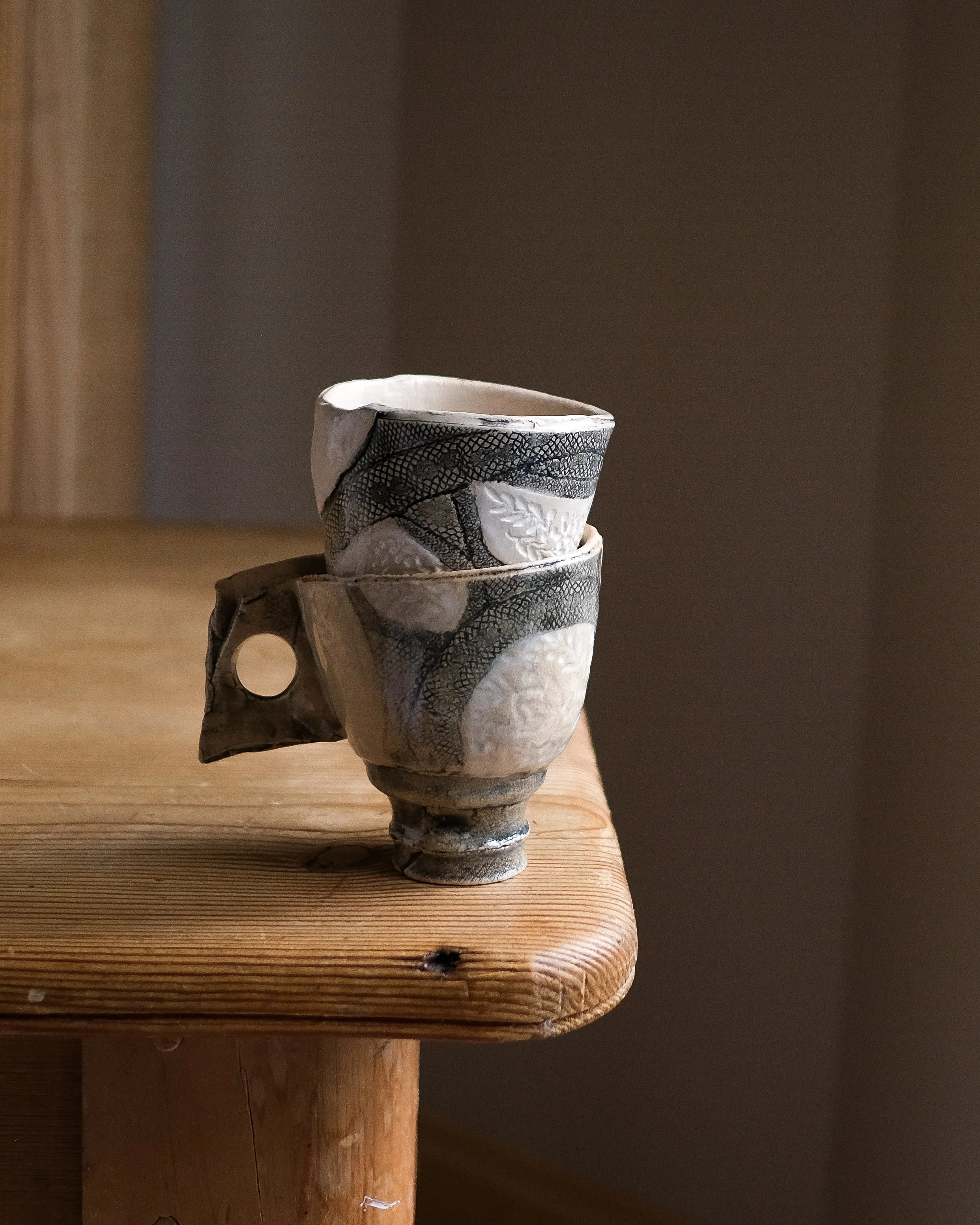 Lacy Cup in black and white handbill with a ring handle and a tall foot