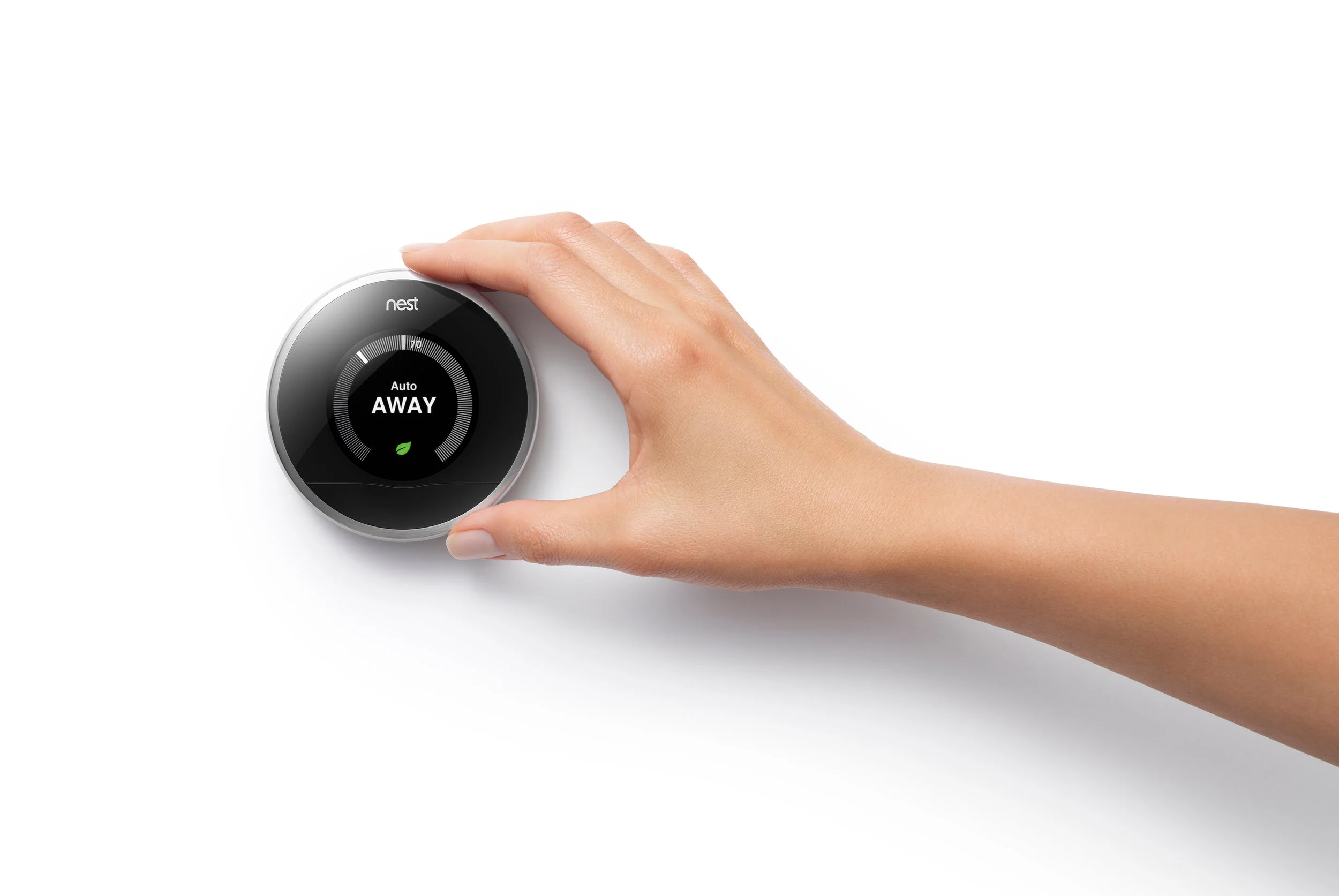 Smart Heating Control Woman adjusting nest thermostat on wall