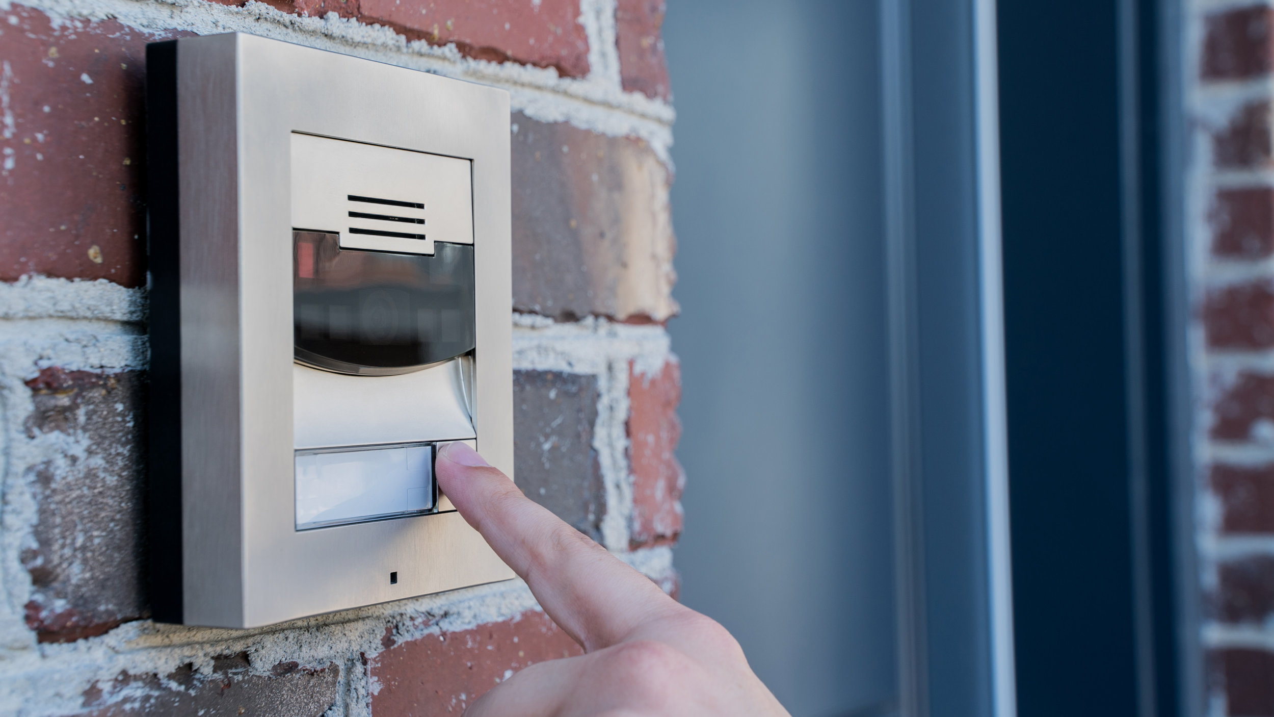 Smart_Home_Security_Video_Doorbell_Control4_Intercom_Anywhere_Red_Brick_Wall_Person_Pressing_Button