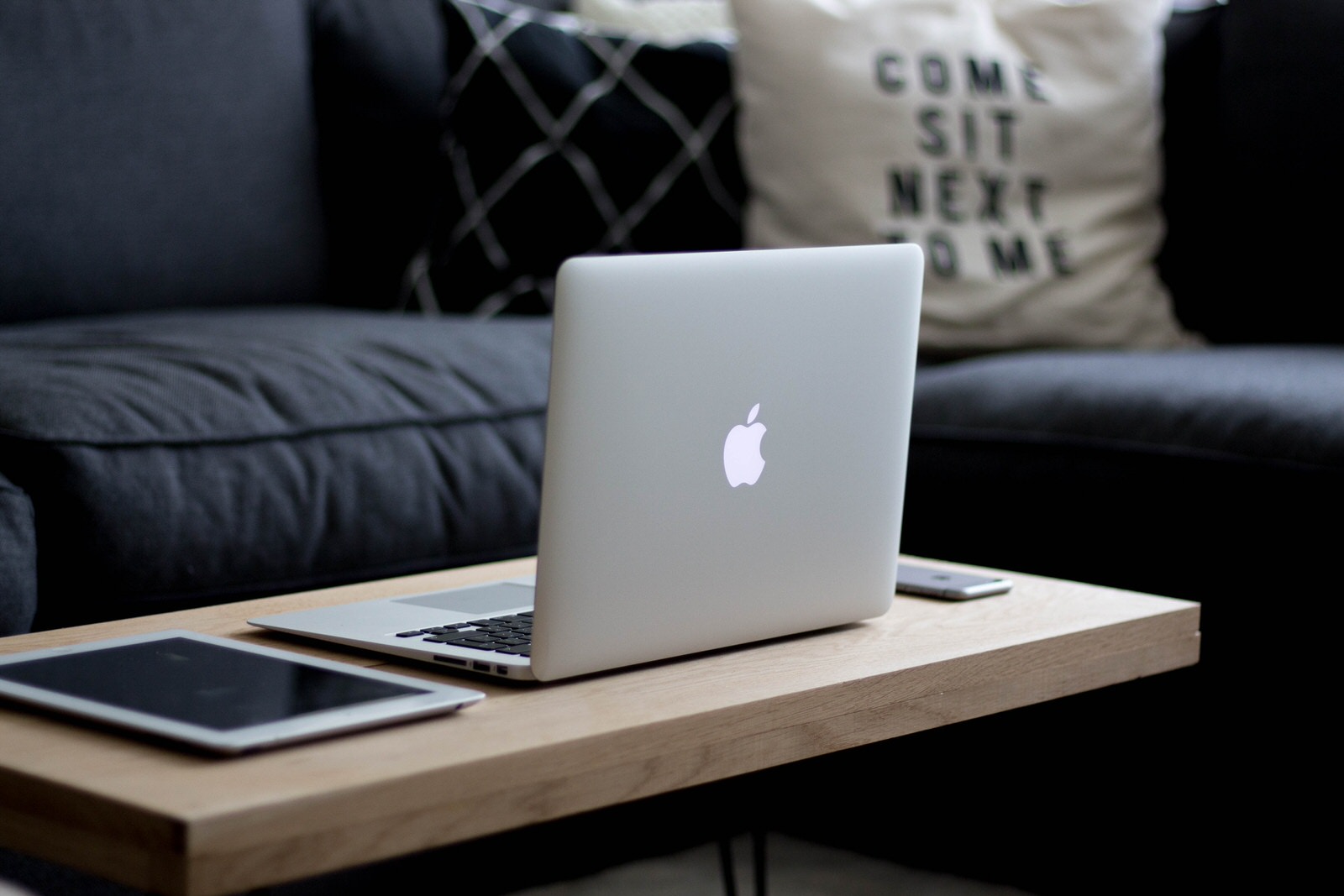 Home_Networks_Mac_Book_Air_Silver_iPad_iPhone_on_Brown_Coffee_Table_Dark_Blue_Sofa