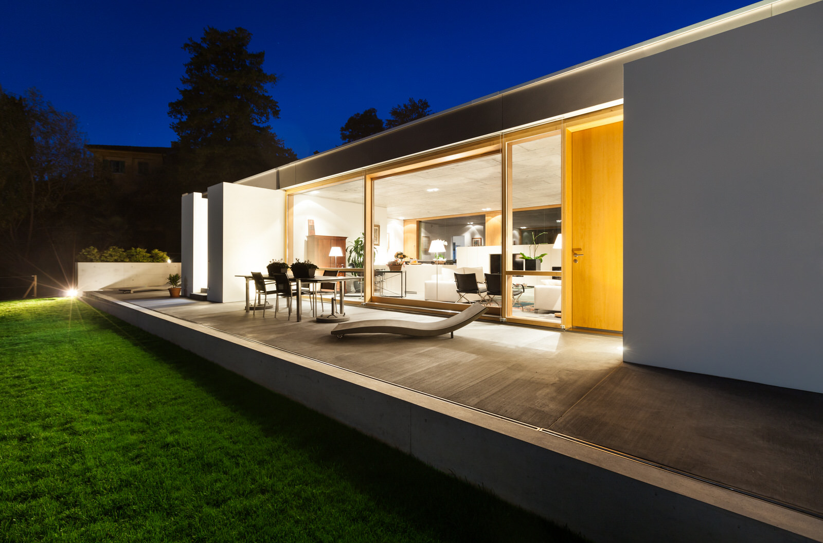 Lutron_Lighting_Modern_Contemporary_Bungalow_Green_Grass_White_Builiding_Deep_Blue_Sky_Warm_White_Lighting_Inside.jpg