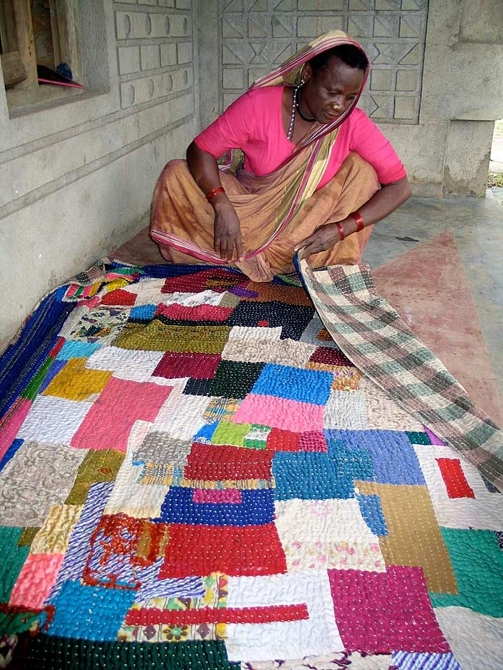 Quilter examining sari backing, Kendalgiri village