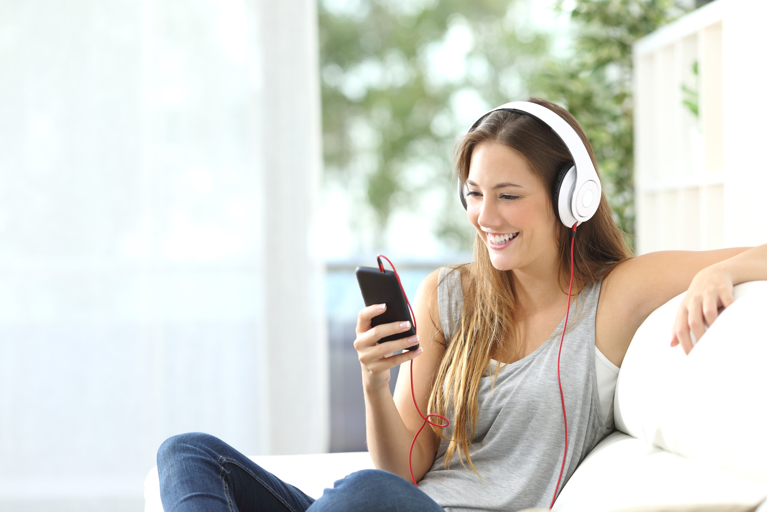 Canva - Happy girl listening to music from mobile phone.jpg