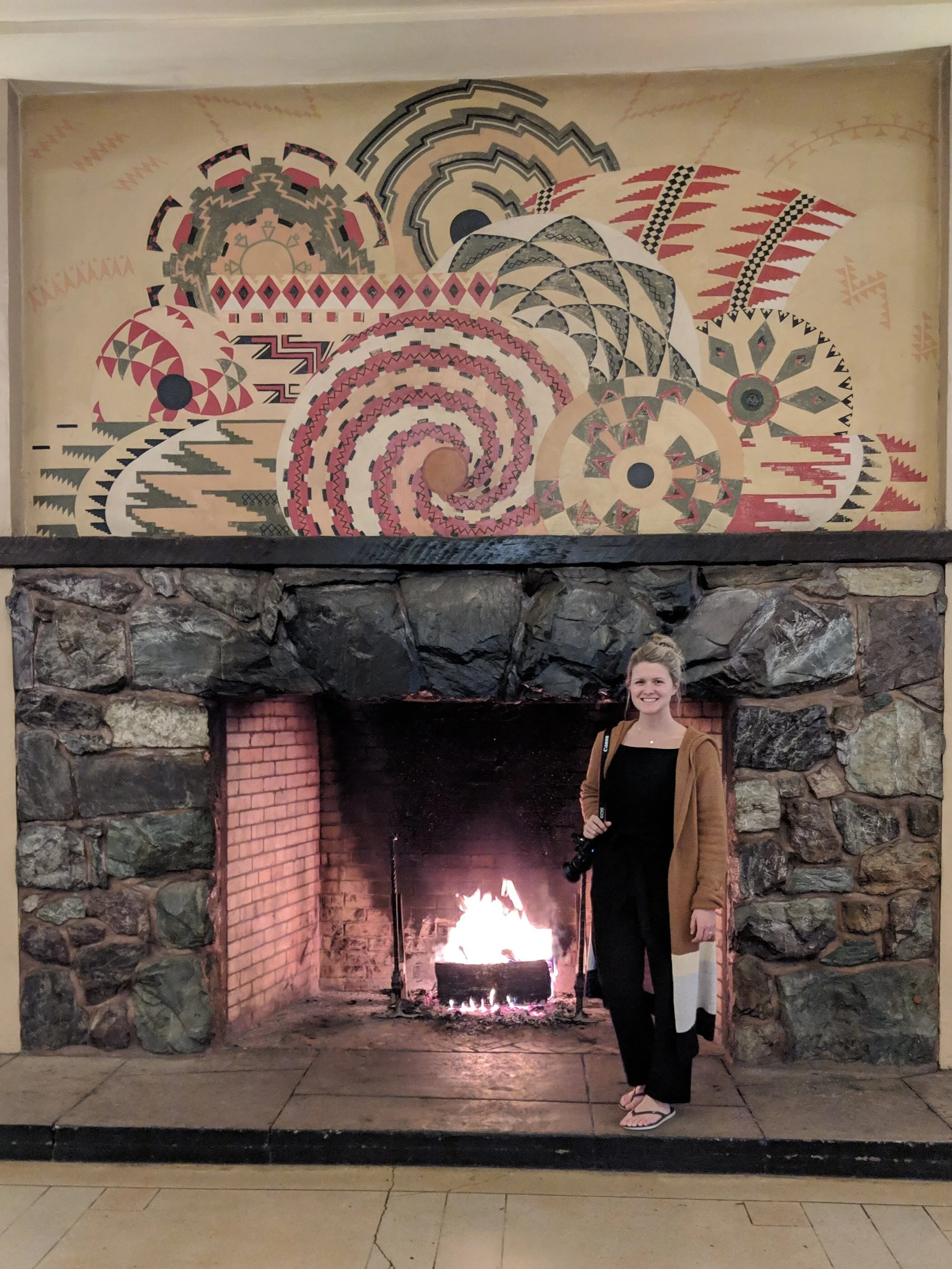 Stone fireplace in hotel. For reference, Sarah is 5’7”.