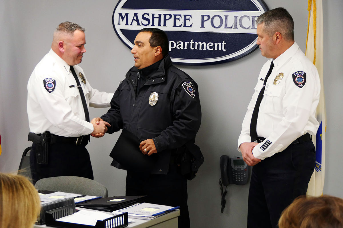 Chief Scott Carline congratulates officer Kevin Frye after presenting him with the distinguished service medal, as newly promoted Lieutenant Olivier Naas looks on. Officer Frye has served with the Mashpee Police Department for 24 years.