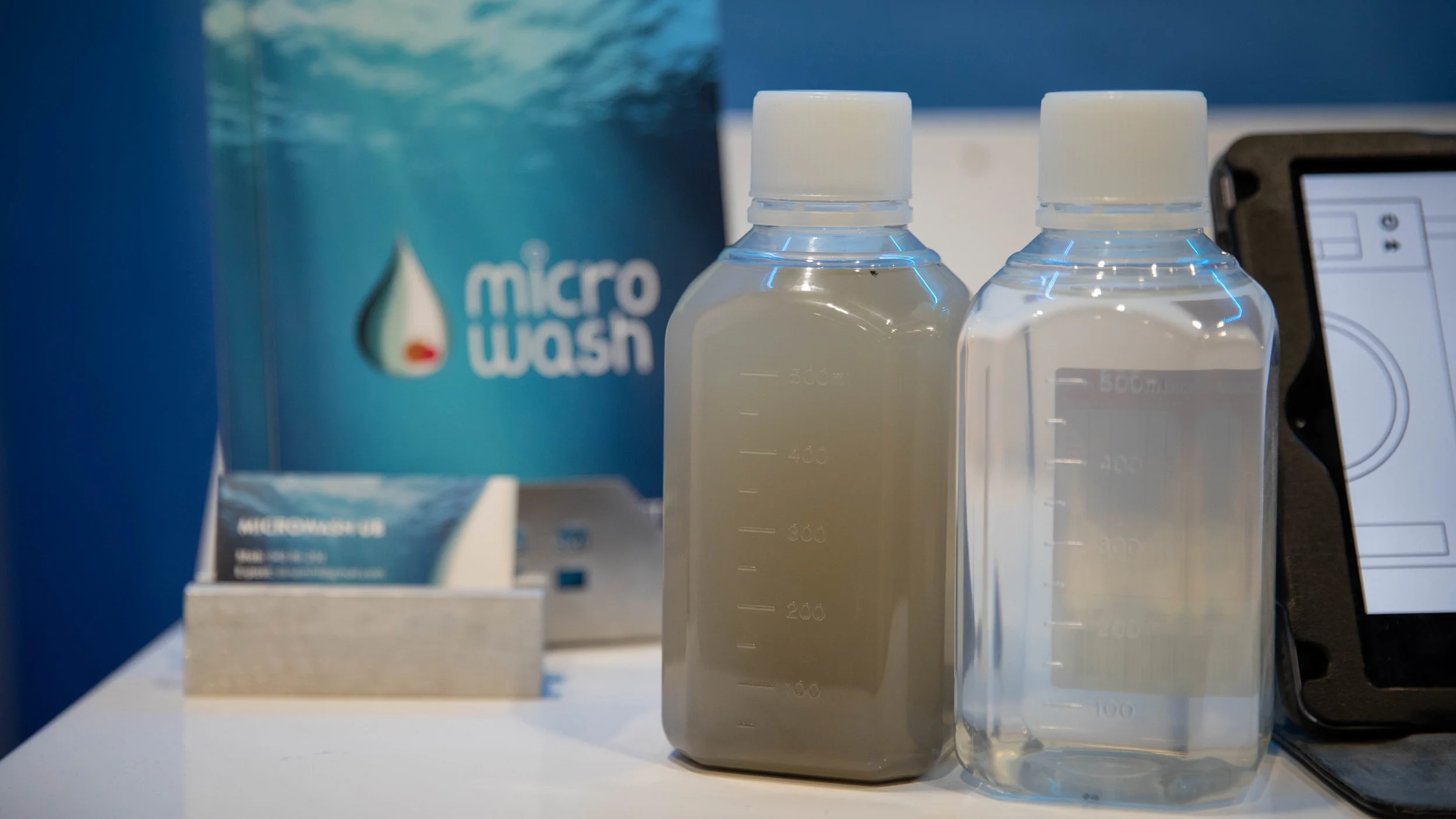 SKILLER UT MIKROPLAST : På standen i Lillestrøm hadde MicroWash UB med seg beviset på at tanken gir effekt: en liten flaske fylt med mørk mikroplast tappet fra tanken etter tre runder med klesvask. Foto: Newslab