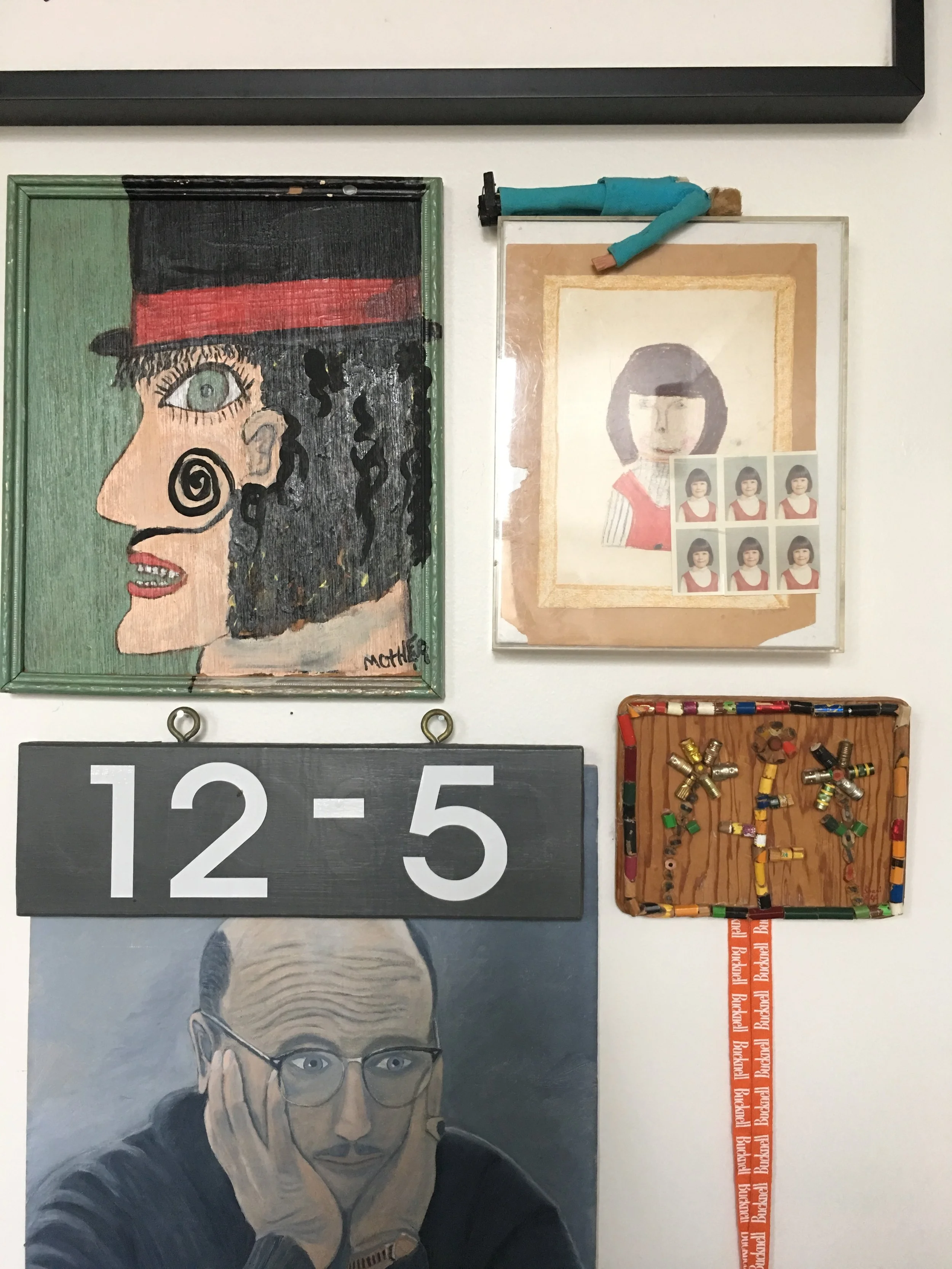 A gallery wall in the library includes an amazing combination of works including family pieces and fun objects like the little man in the blue suit above a childhood self portrait.