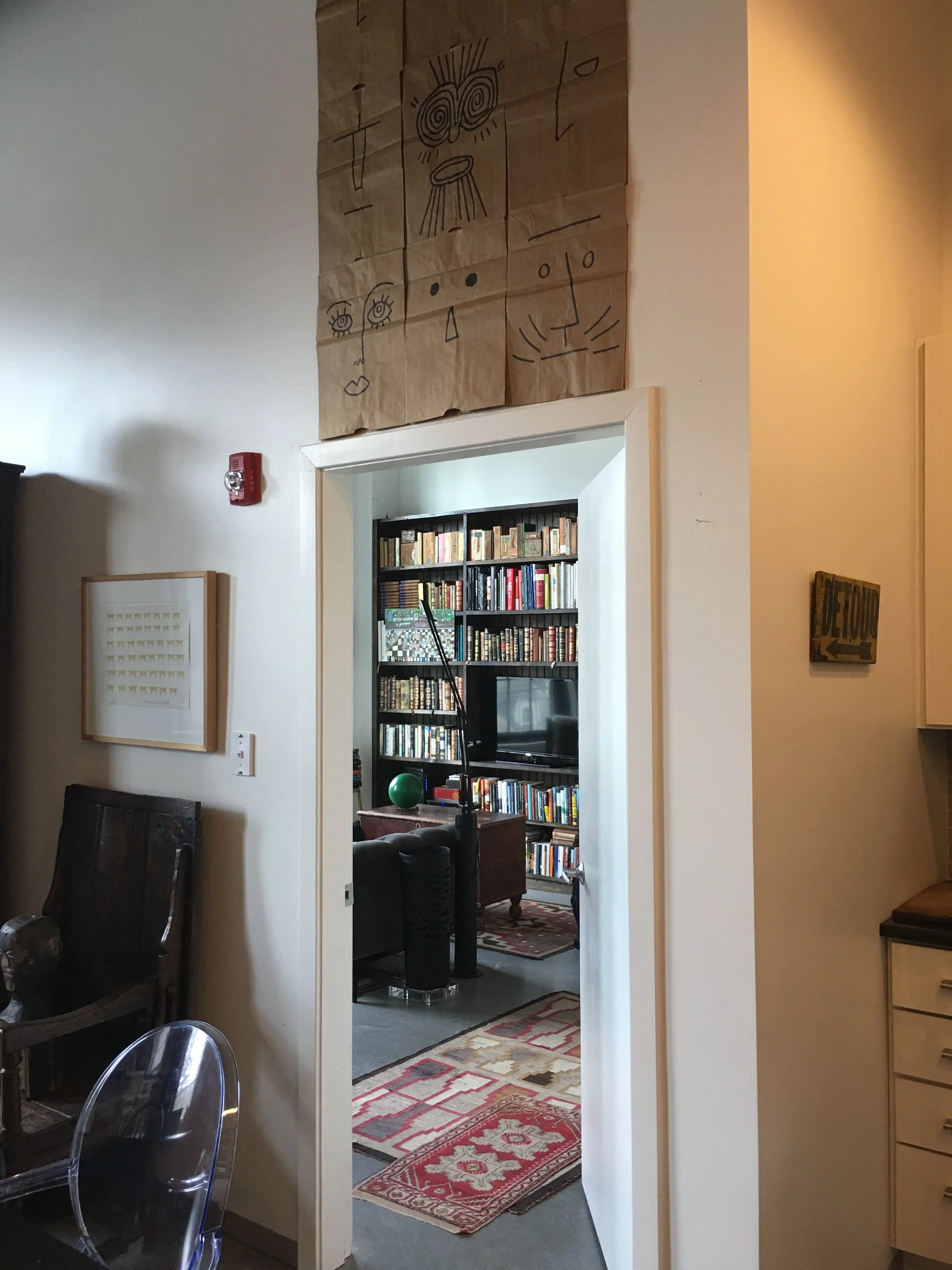 A wooden head on a chair as faces view the room from above the door, you catch a glimpse into the stunning library. I was delighted to see the cigar box collection in the bookcase.