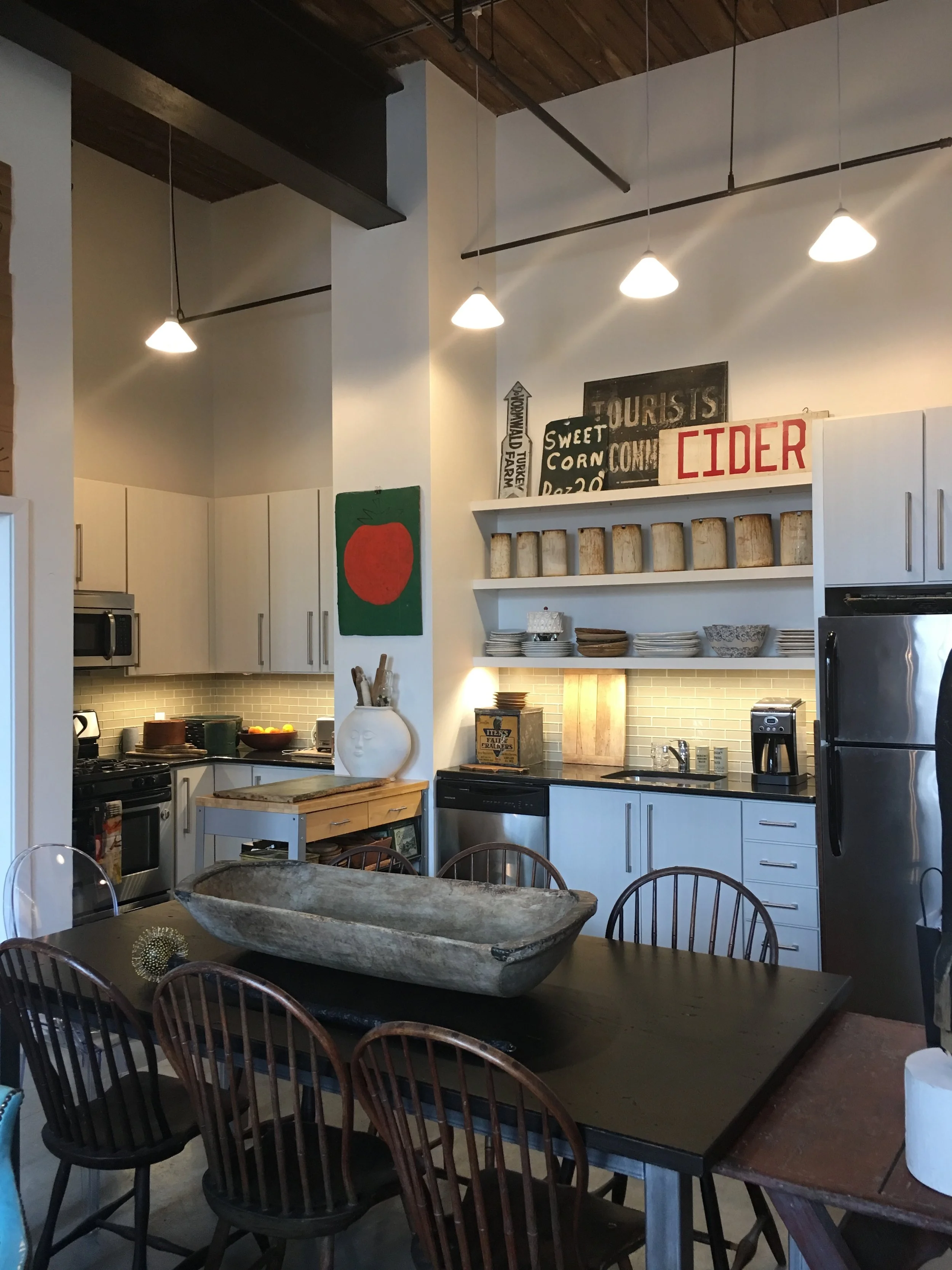The kitchen contains so many eye catching vignettes. A rolling pin collection in a large face, a cake on wheels, a farm stand sign, and a gorgeous white bucket collection draw your eye into the marvelous kitchen.