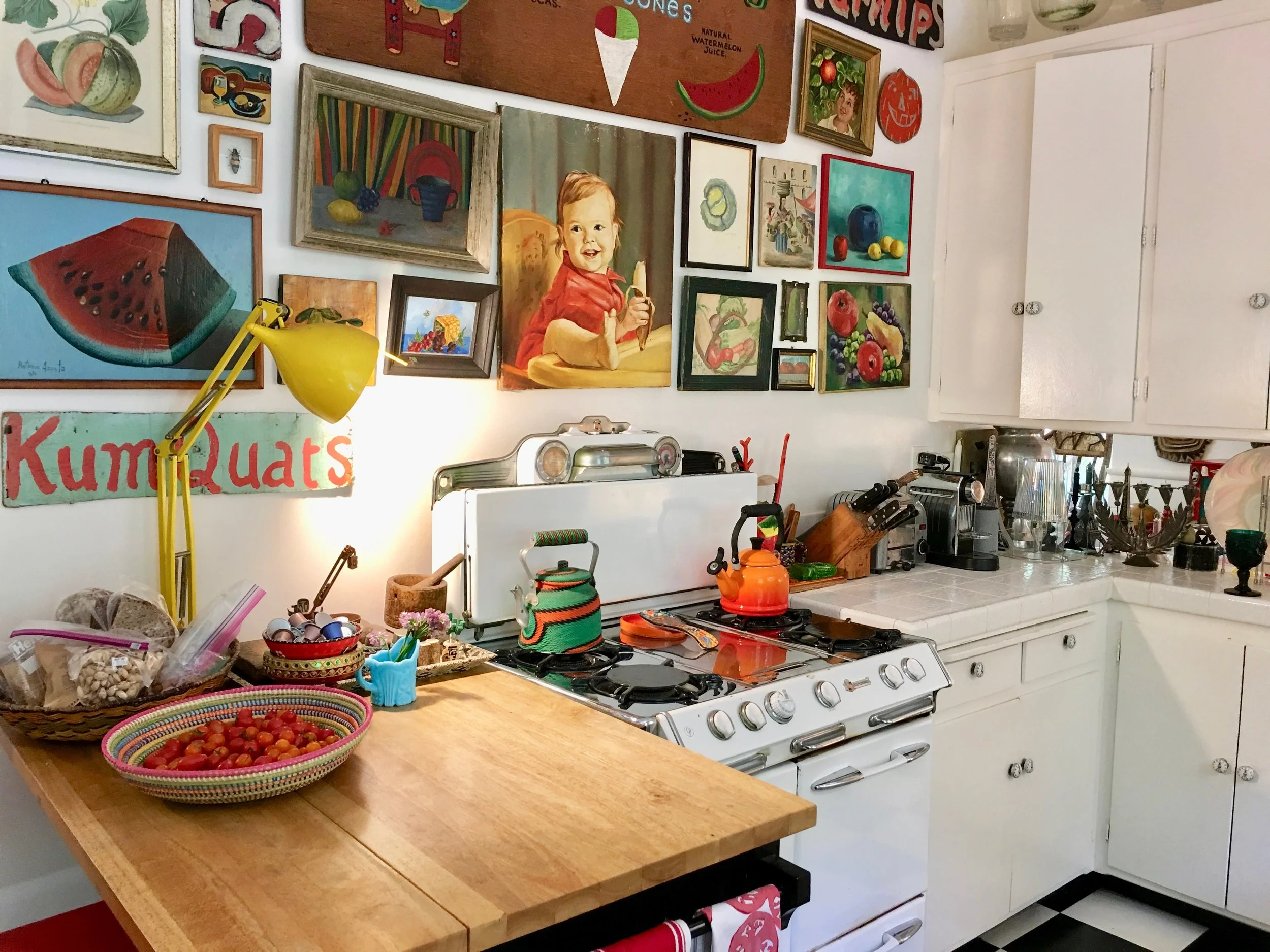 A white backdrop, an antique stove, and am amazing art collection made me never want to leave this kitchen.