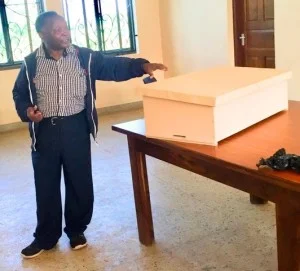 Professor Msalilwa displays one of the 10 beehives SEGA purchased. 