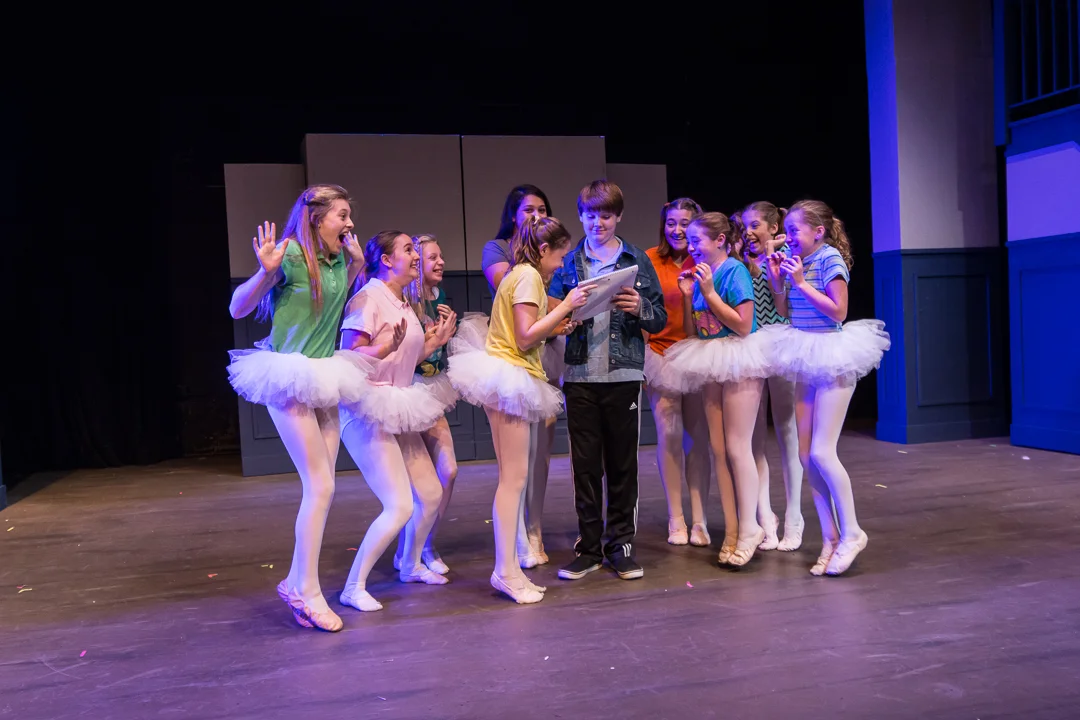 Billy Elliot (Ryan Vanselow) meets with the excited ballerina girls in a scene from Waukesha Civic Theatre’s “Billy Elliot.”