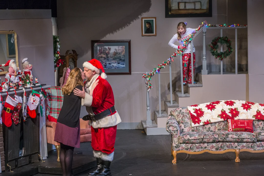 Judy (Jen Hull Anderson) and husband Bill (Mike Anderson) are being watched by their surprised daughter Stella (Emily McCaskey), who later joins her siblings in singing “I Saw Mommy Kissing Santa Claus” during Waukesha Civic Theatre’s “Candy Cane Tales and Holiday Carols.”