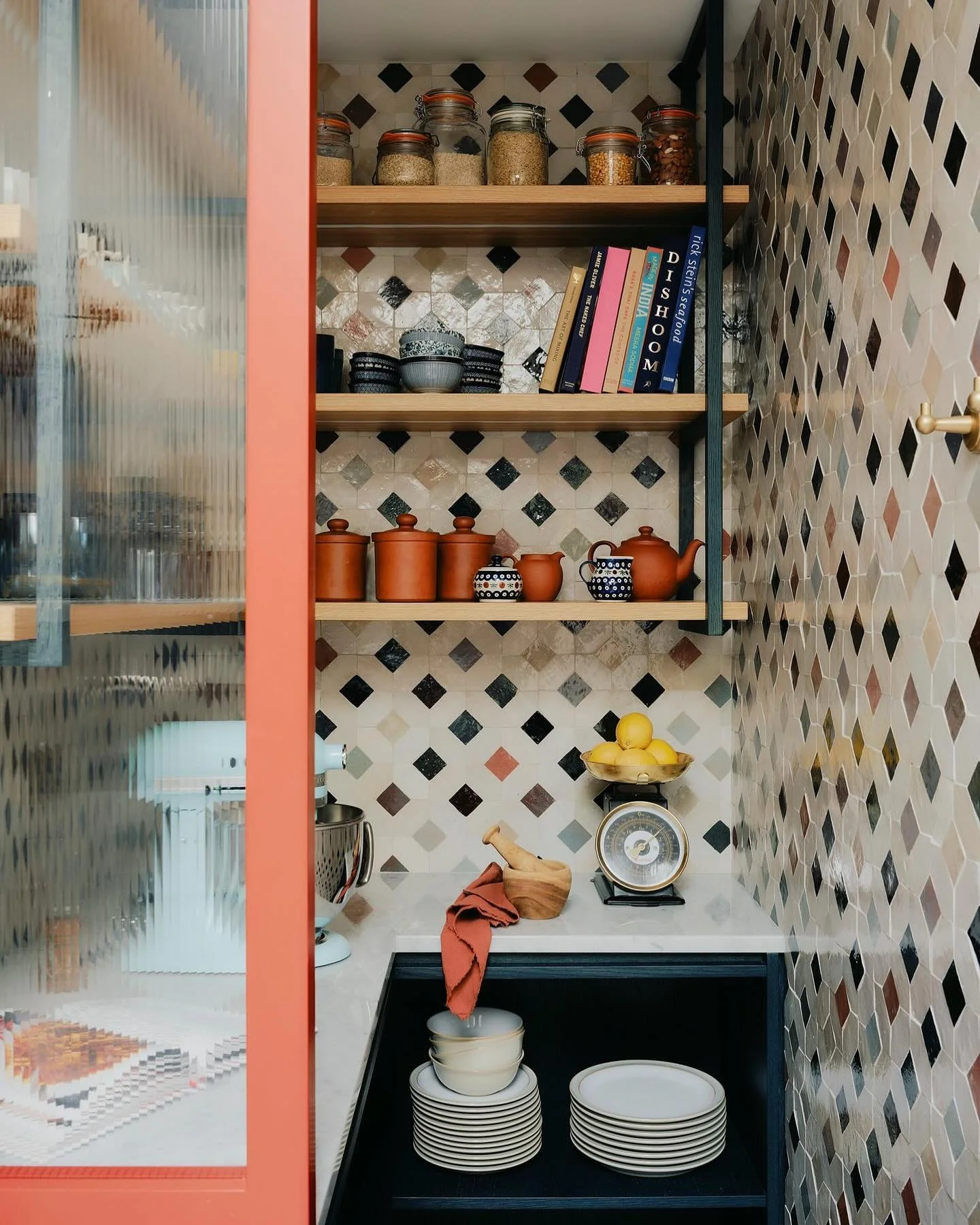 A glorious little pantry, which is a divided from the main kitchen by a slim reeded glass panel, painted in &lsquo;Tuscan Red&rsquo; and covered in colourful mosaic zellige tiles. We worked with @creativedge_furniture to build the kitchen cabinetry w