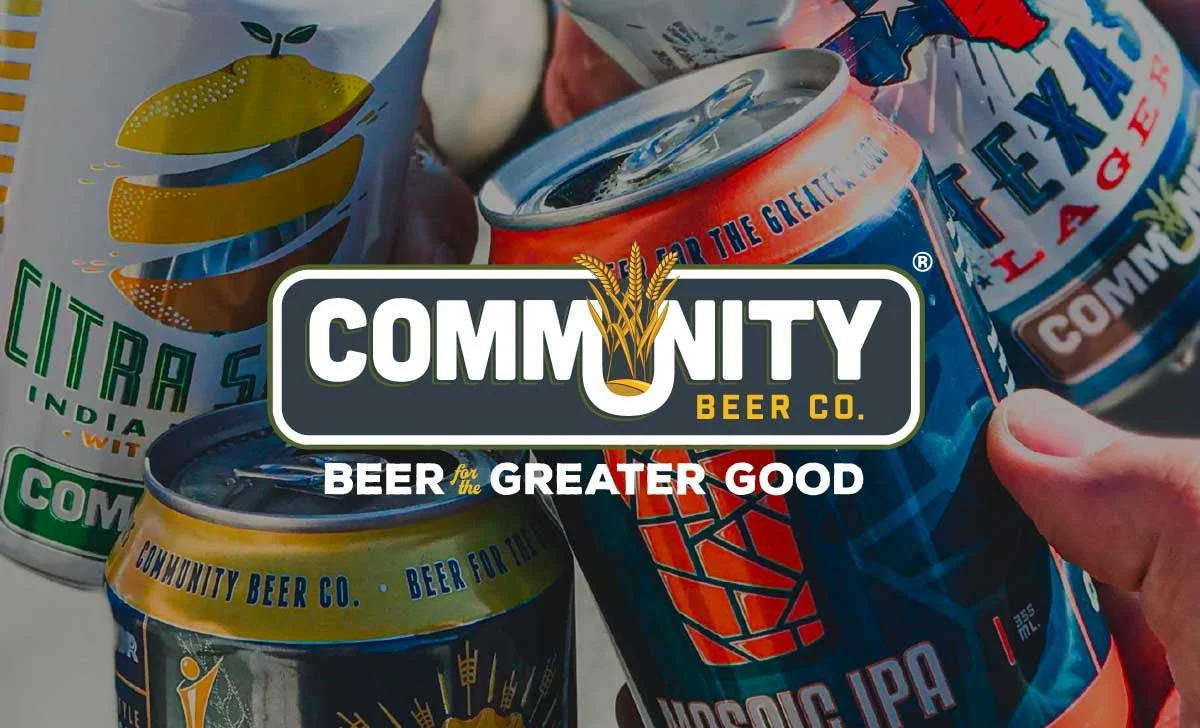 Several cans of Community Beer Co. beer, including a Citrus Slice India Pale Ale, a Classic IPA, and another variety, held by a person's hand with the company's logo and slogan overlaid.