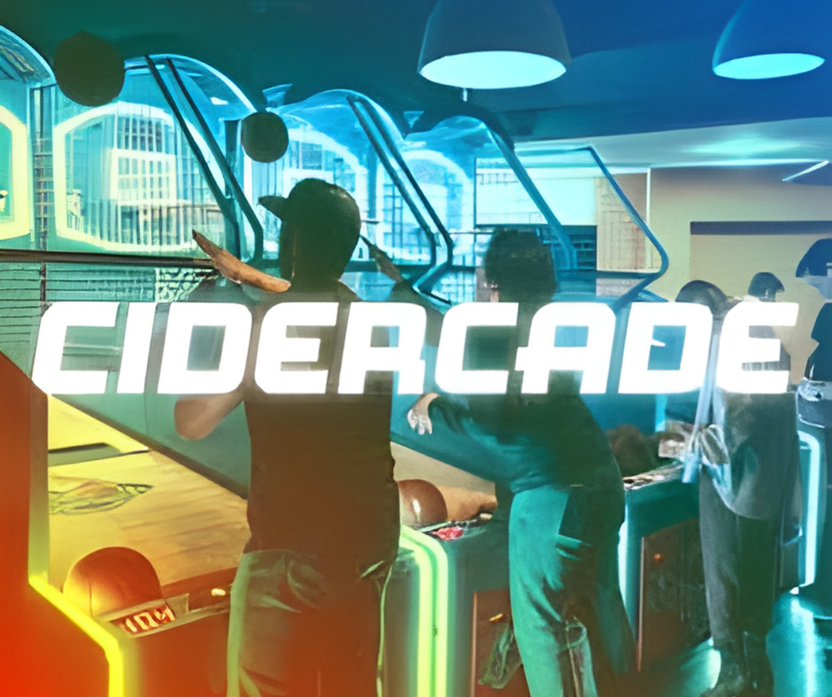 People playing arcade basketball game at Cidercade with neon lighting and city view through windows