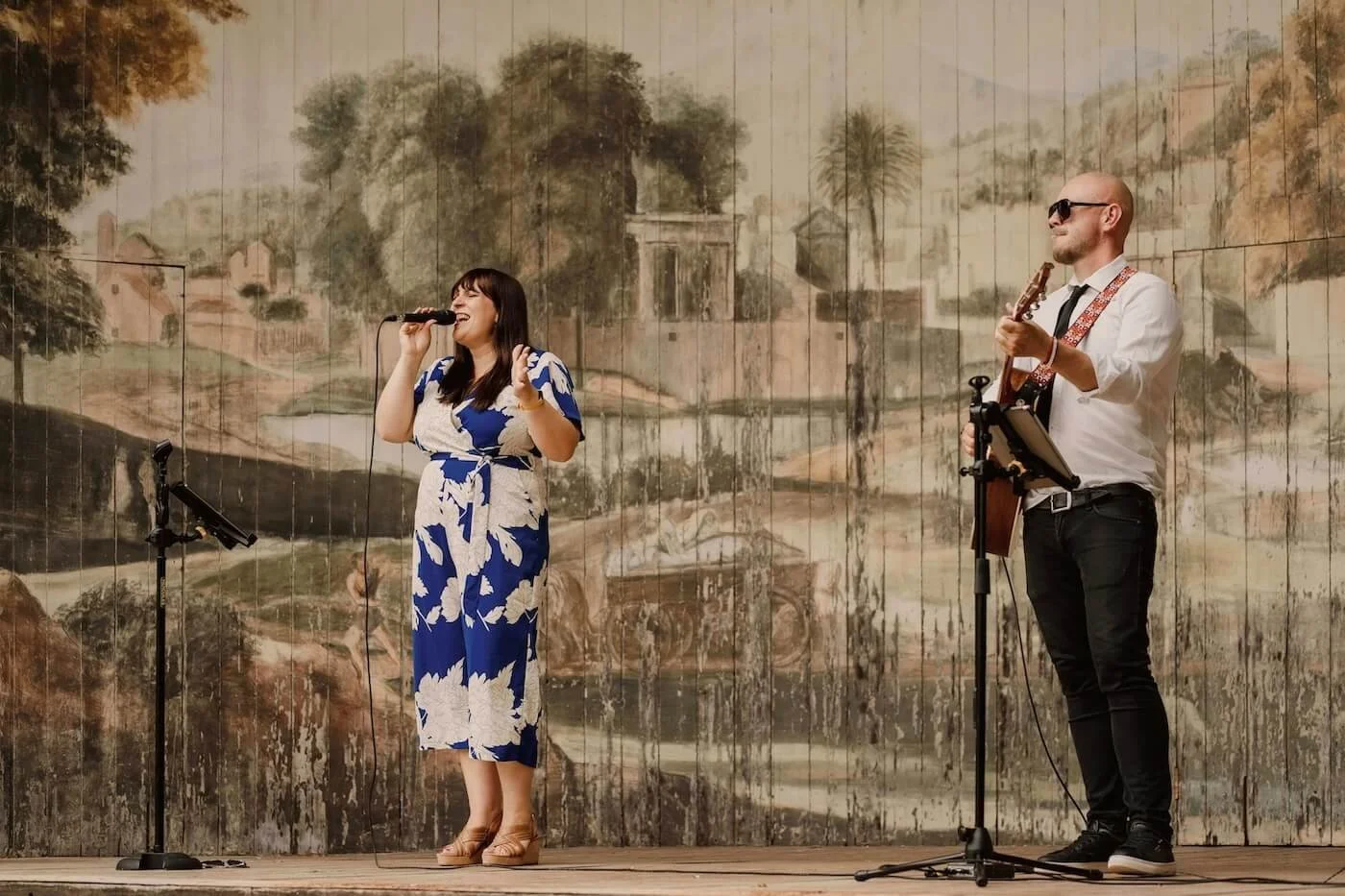 Soulstar acoustic duo performing on the Singing Theatre stage at Larmer Tree. Man is playing acoustic guitar and woman is singing